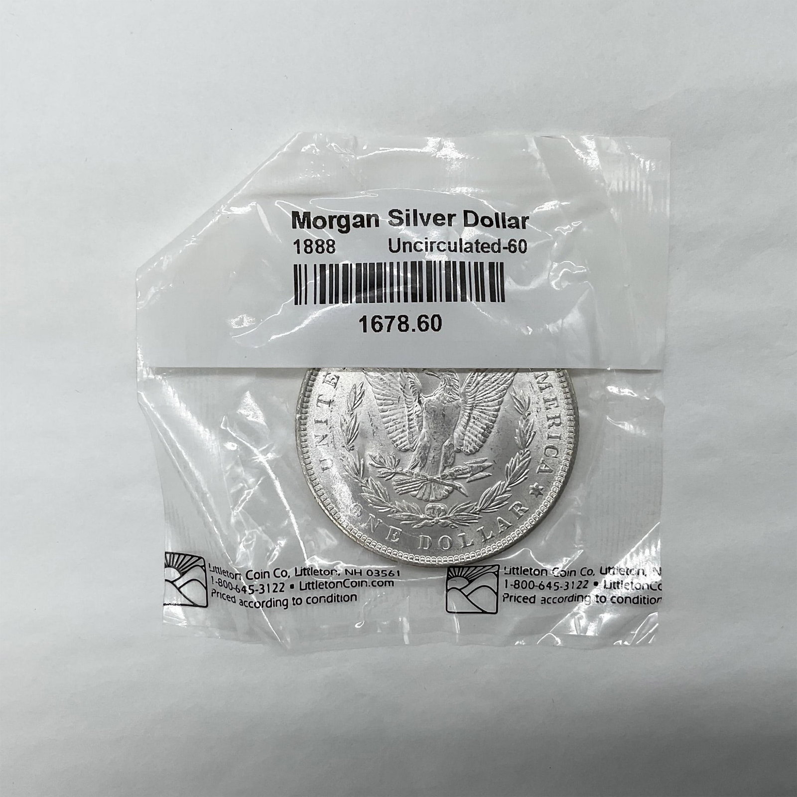1888 Morgan Silver Dollar Uncirculated 60: The obverse side features Liberty in profile. She is shown in cap, flora, and crown. The reverse side depicts an eagle with outstretched wings gripping arrows and an olive branch. The coin is in an or