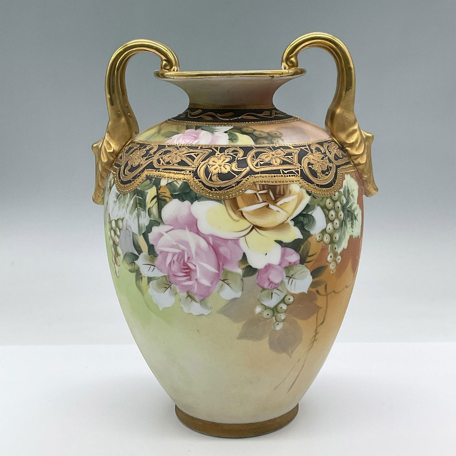 Vintage Nippon Double Handle Porcelain Vase: This gorgeous hand painted lackluster vase includes floral motifs and a black and gilded floral pattern as well as gilded gold handles. Nippon backstamp. Issued: 20th century Dimensions: 7"L x 6"W x 9