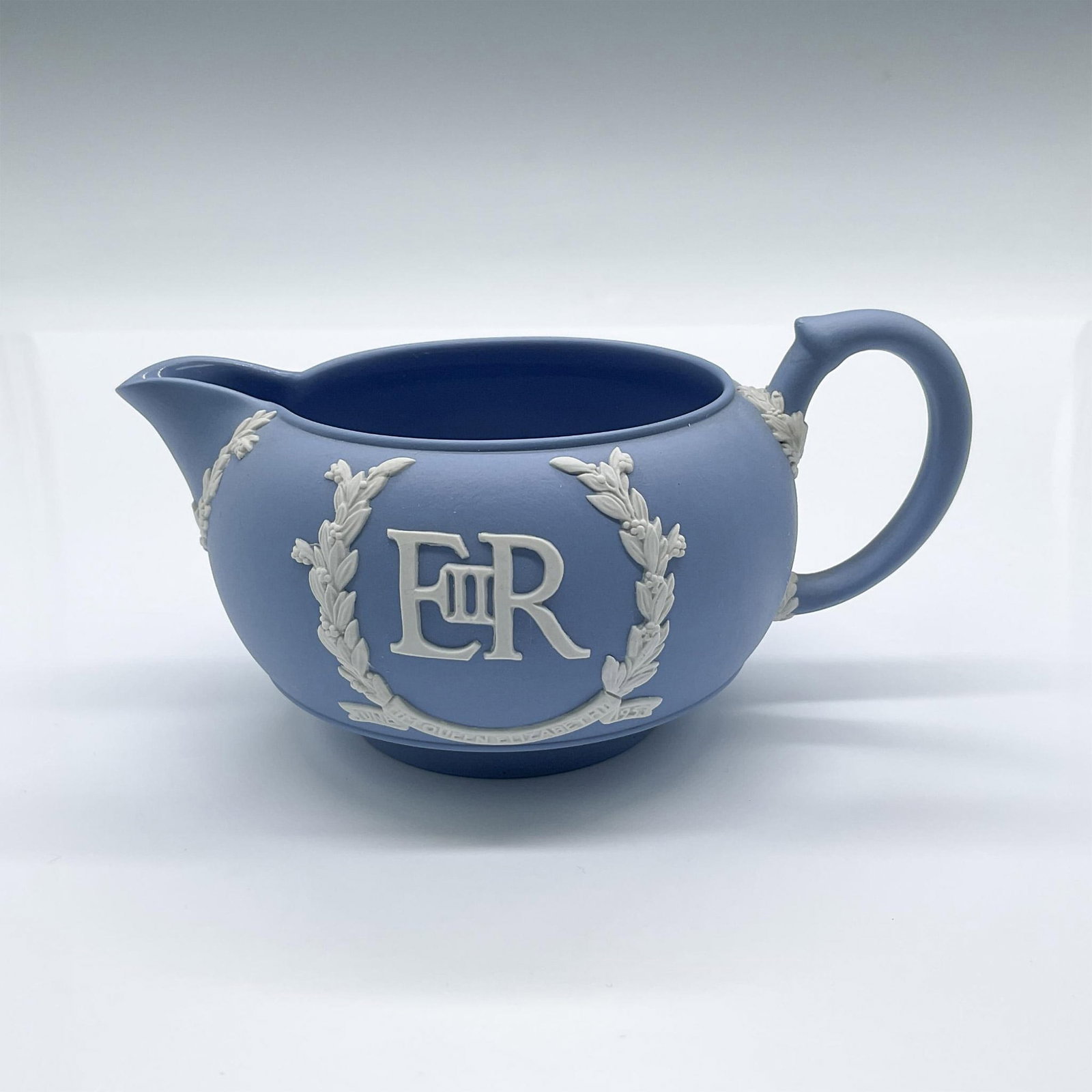 Wedgwood Pale Blue Jasperware Elizabeth II Regina Creamer: An English blue pottery cafeware. Decorated in white the ER II, the royal cypher for Queen Elizabeth II, and Dieu Et Mon Droit, the coat of arms of the United Kingdom. Wedgwood Made In England stamped