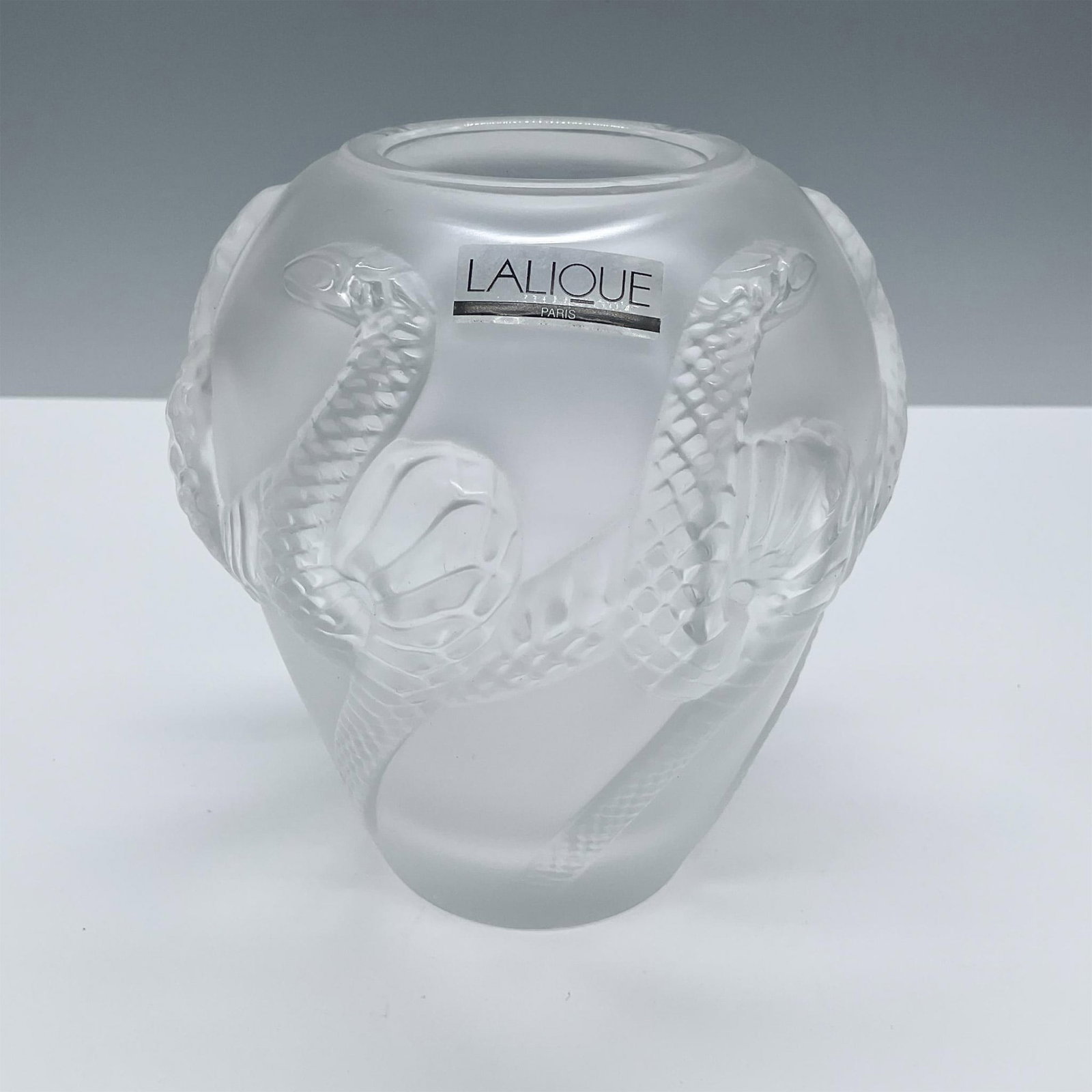 Lalique Crystal Charmeur Serpent Vase: Beautiful frosted crystal vase with a serpent relief pattern. Lalique etched signature on back. This item has its original box which measures: 7''L x 5''W x 5.25''H. Issued: 20th century Dimensions: 4