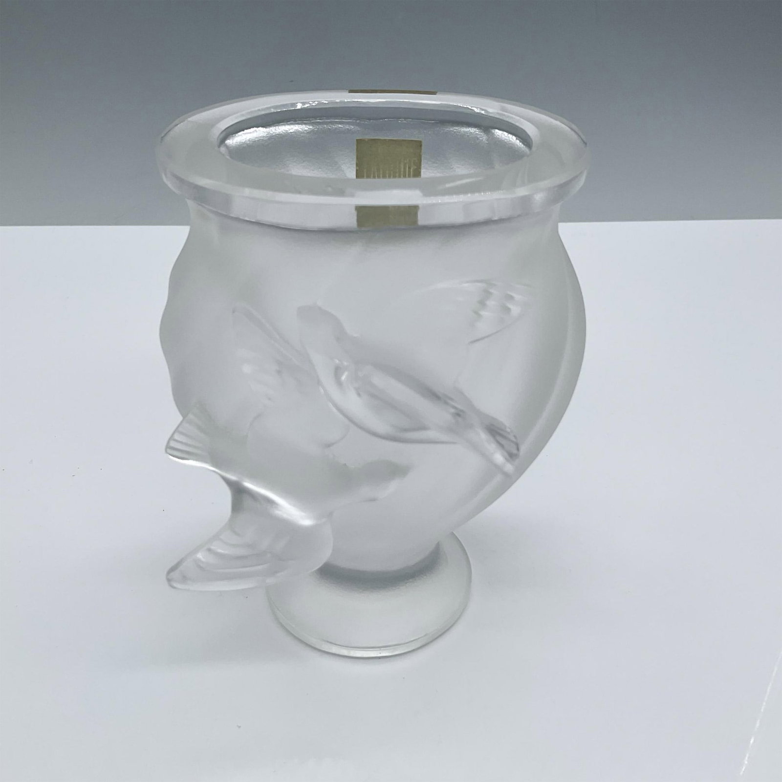 Lalique Frosted Rosine Vase, Two Doves: Rosine pattern frosted crystal glass vase features two doves mid-flight. Vase itself has a graceful slanted ribbed swirl design on the body. Lalique France backstamp. This item has its original box. B