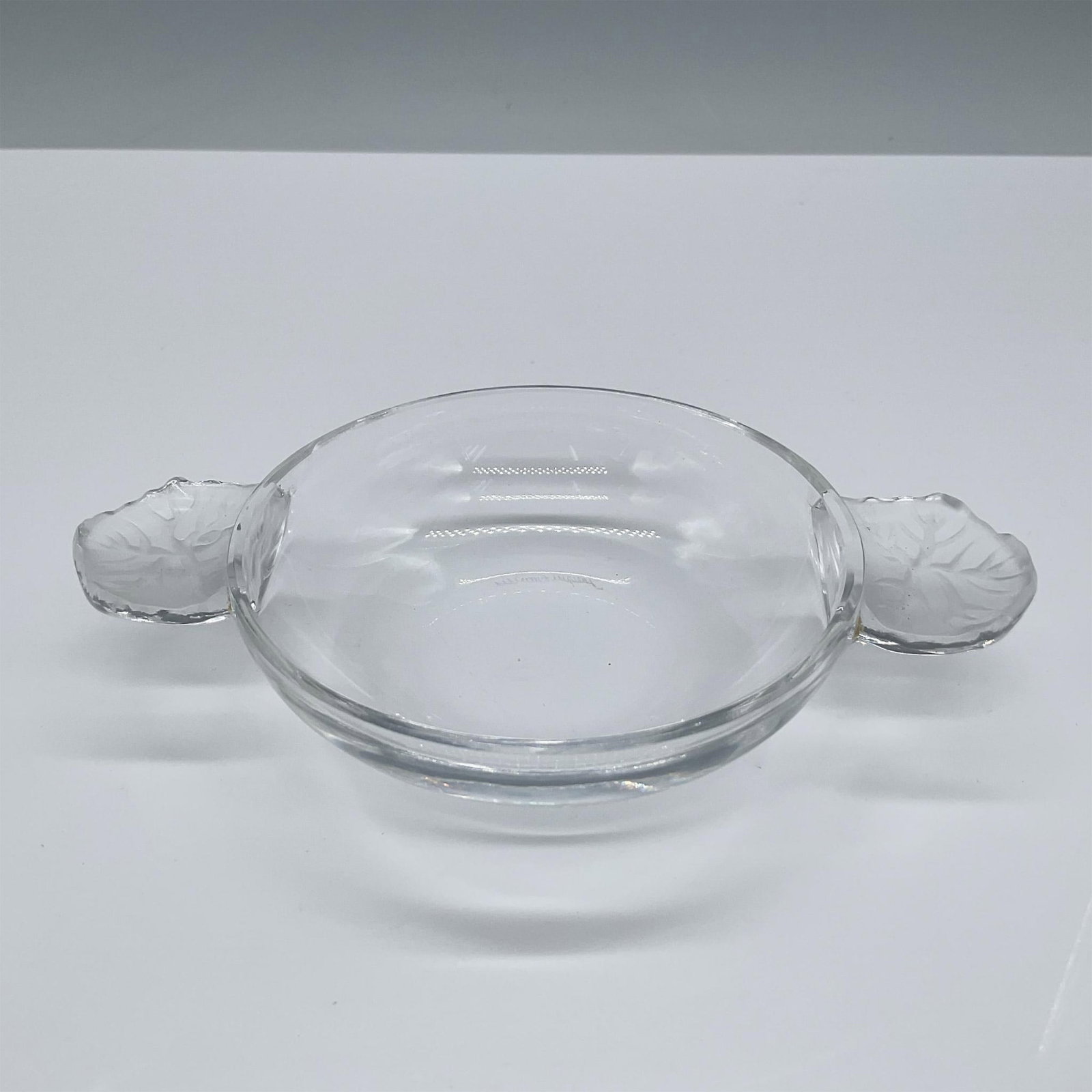 Lalique Crystal Dish, Honfleur: Beautiful clear crystal dish bowl with frosted handles. Lalique engraved signature on base. This item has its original box, which measures: 5.25''L x 5.25''W x 2.5''H. Issued: 20th century Dimensions: