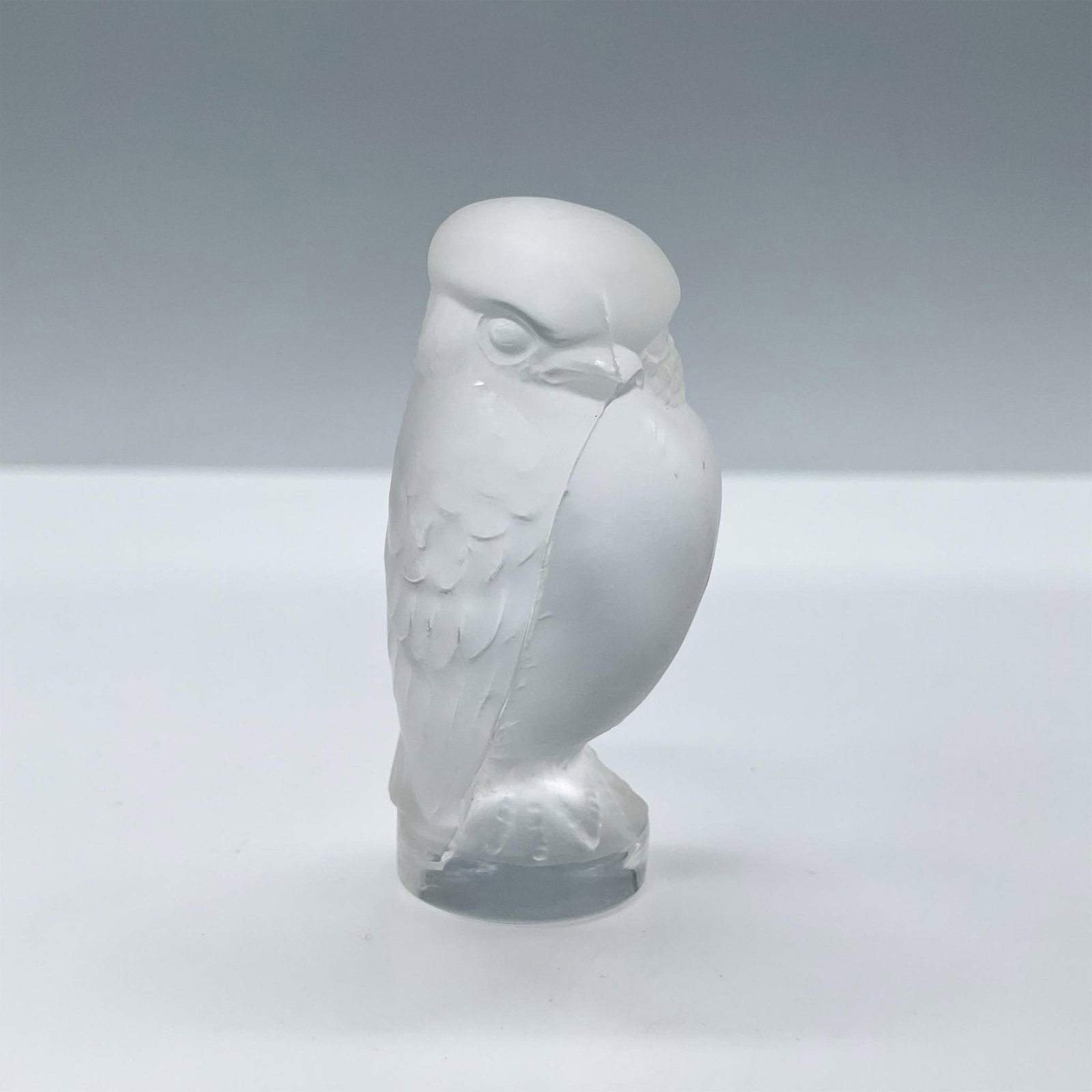 Lalique Frosted Crystal, Owl: Adorable frosted owl sitting on a clear base. Used as a place card holder. Lalique France etched on the side of the base. Dimensions: 2"H x 1"dia. Manufacturer: Lalique Country of Origin: France