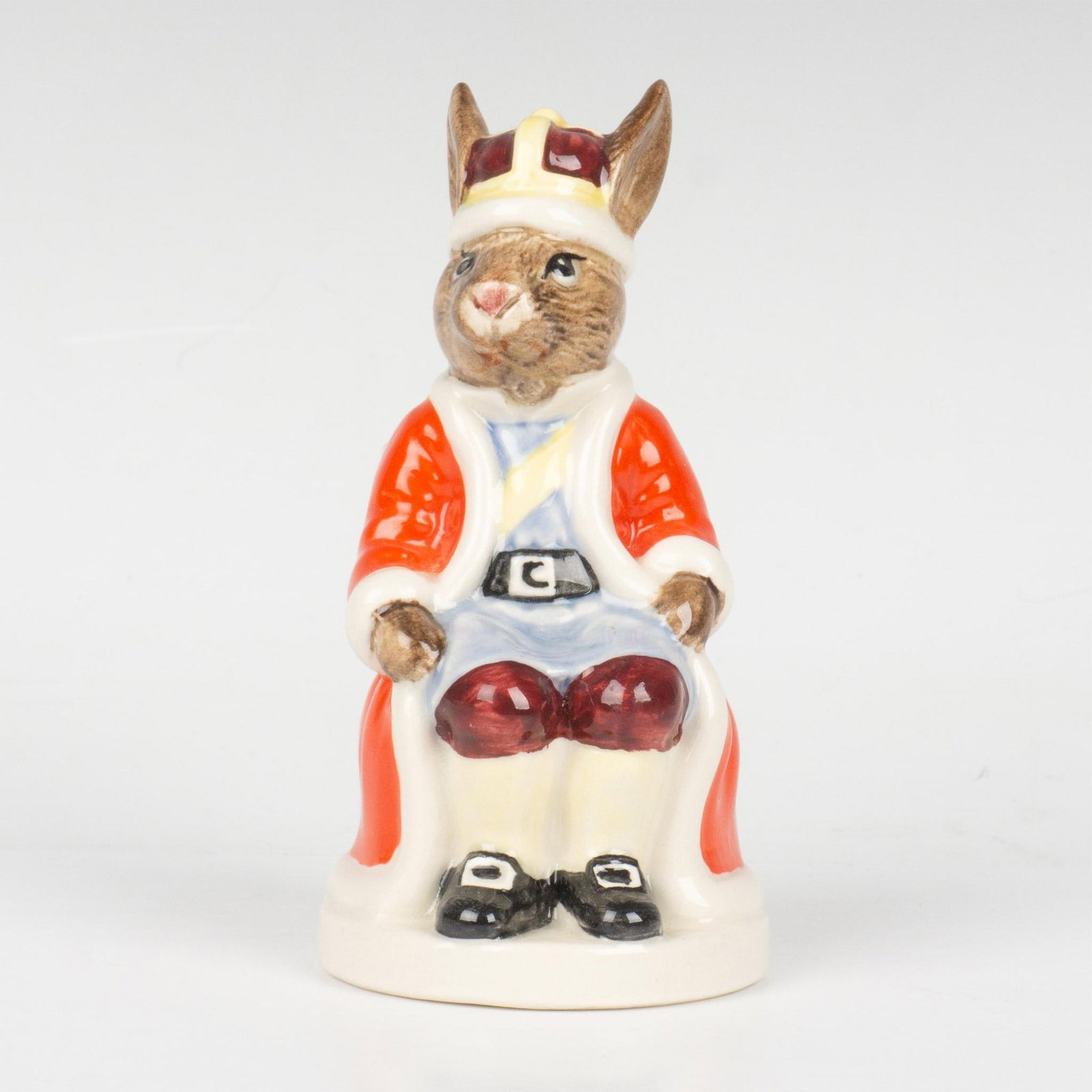 King John DB45 - Royal Doulton Bunnykins: A royal figure sitting on a throne, wearing a red coat and dark red and yellow crown. Royal Doulton backstamp. Artist: H. Sales Issued: 1986 - 1990 Dimensions: 4"H Manufacturer: Royal Doulton Country 