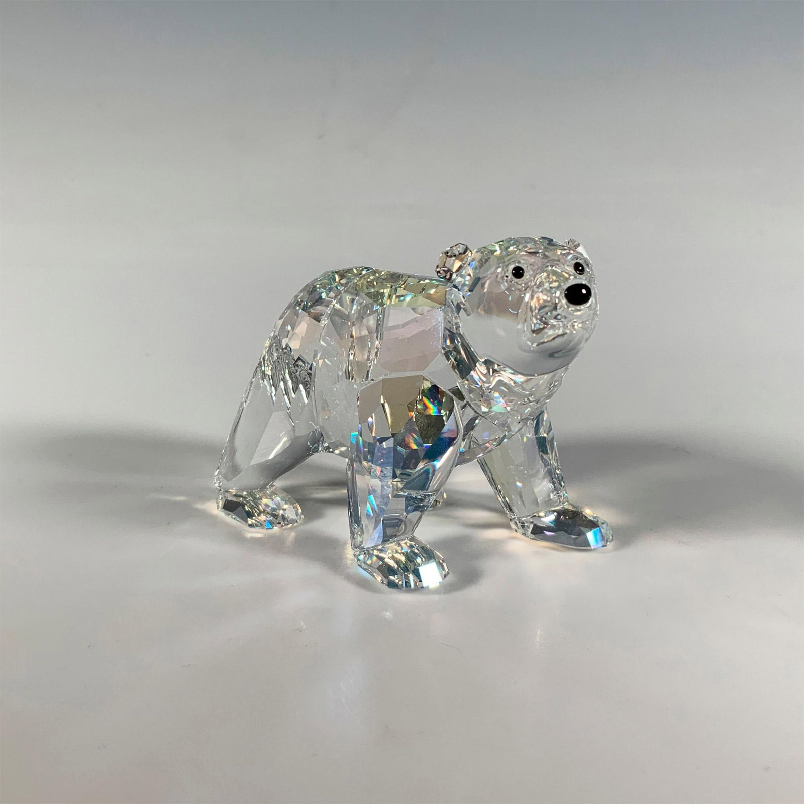 Swarovski Crystal Figurine, Polar Bear: A radiant faceted moonstone crystal figure of a polar bear featuring smooth black eyes and nose. Swarovski marking. Artist: Anton Hirzinger Issued: 2011 Dimensions: 3.25"L x 2"W x 2"H Manufacturer: Sw