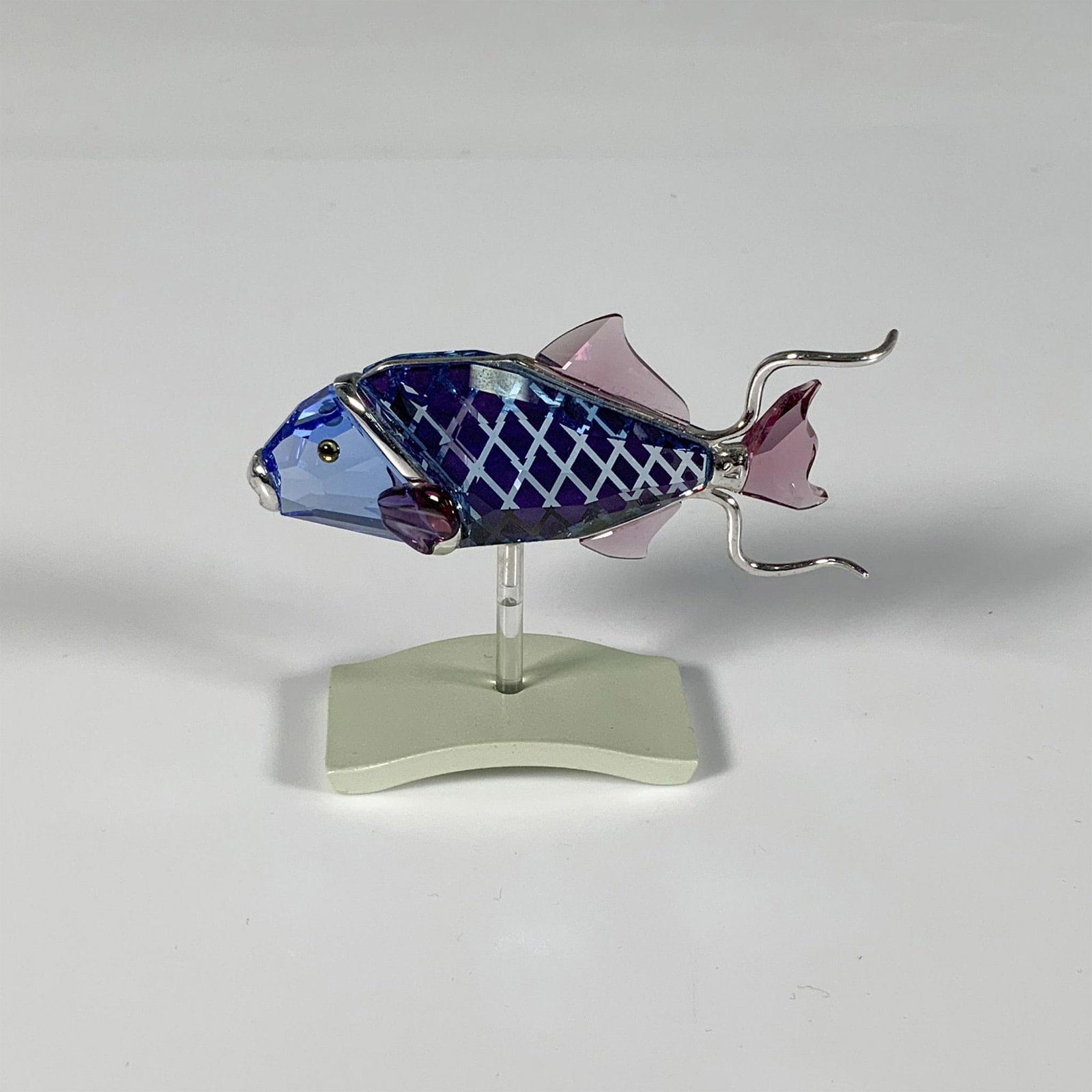 Swarovski Crystal Fish Figurine, Coporta Aquamarine: Part of the Exotic Fish and South Sea collection, this luminous aquatic figure is crafted from blue and purple crystal, embellished with silver-toned accents. Swarovski marking. This item has a base i