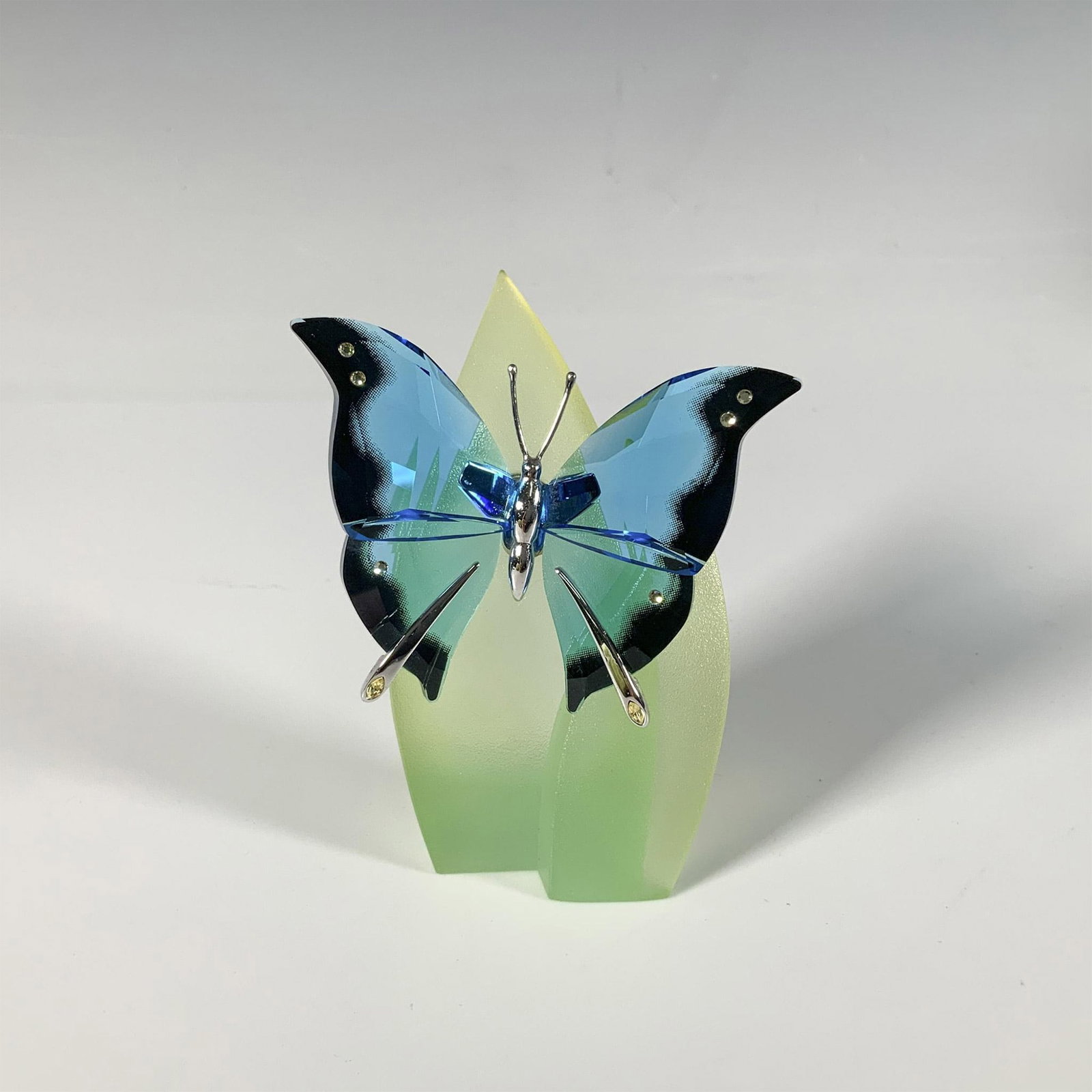 Swarovski Crystal Butterfly Figurine, Ambur Turquoise: Part of the Exotic Butterflies collection, a vibrant butterfly with blue crystal wings adorned with clear gemstones and a sterling silver body. Swarovski marking. This item has a leaf base included: 2