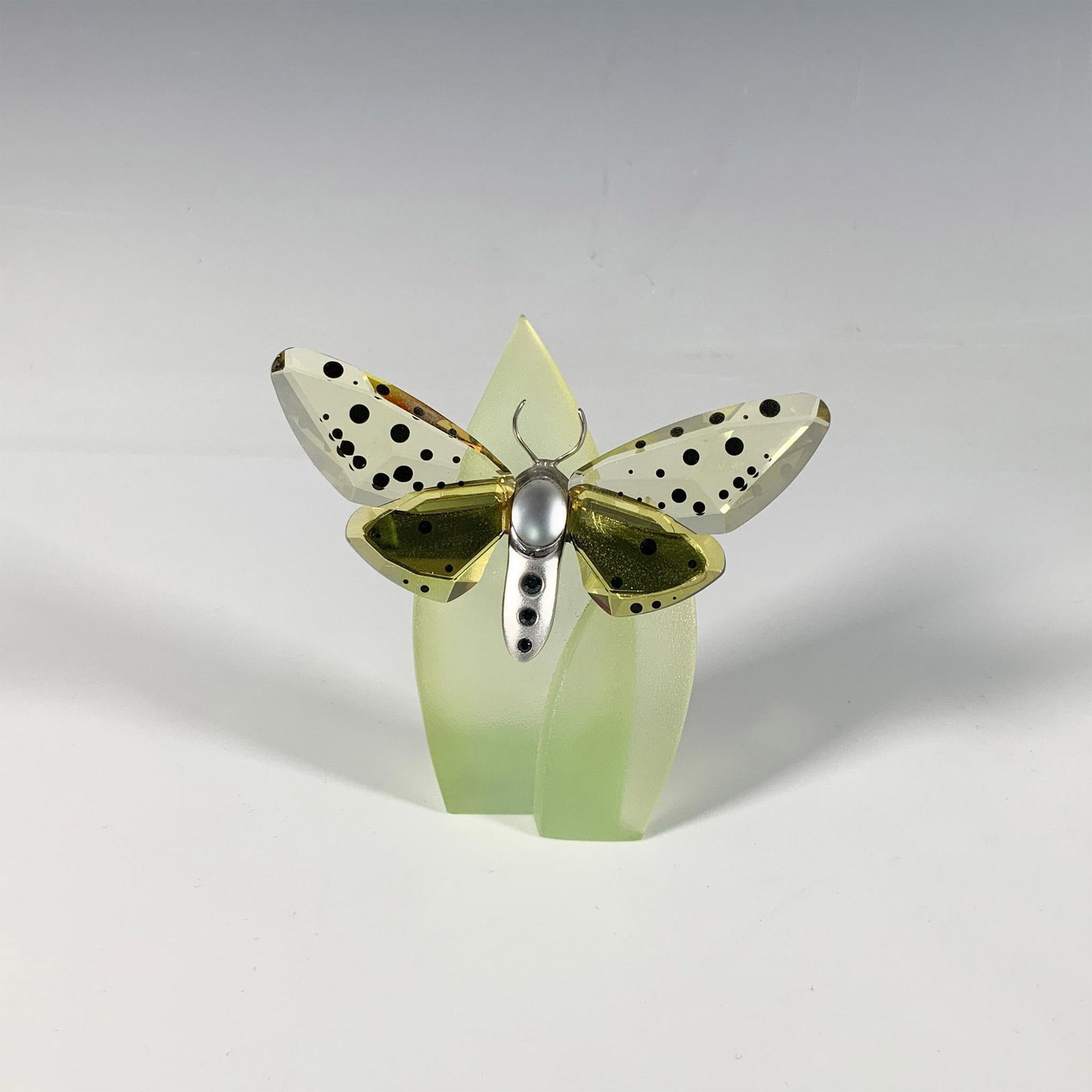 Swarovski Crystal Butterfly Figurine, Amorita Jonquil: Part of the Insects and Butterflies collection, a stunning butterfly with spotted yellow crystal wings and a sterling silver body. Swarovski marking. This item has a leaf base included: 2"L x 1.5"W x 