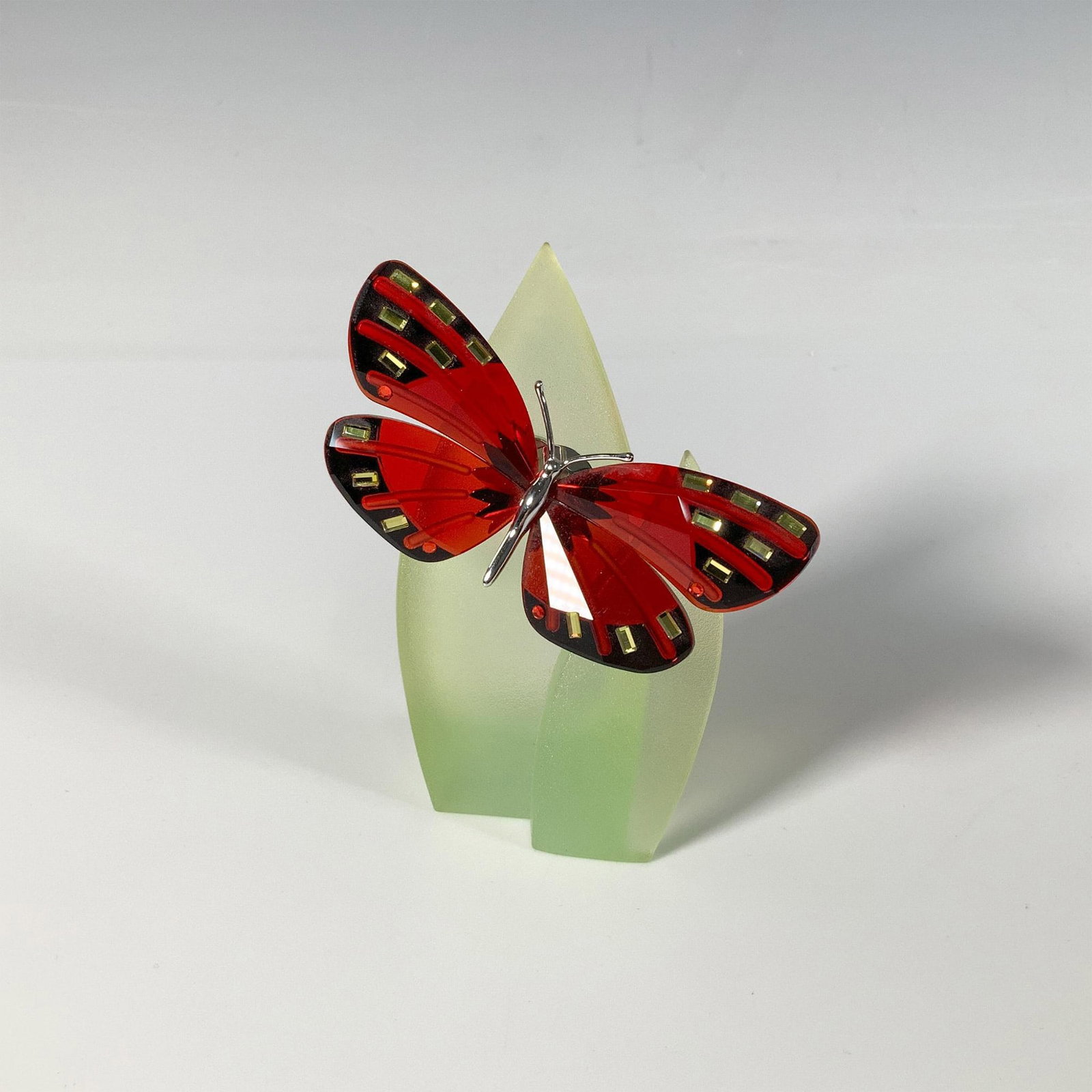 Swarovski Crystal Butterfly Figurine, Adena Light Siam: Part of the Exotic Butterflies collection, a dazzling butterfly with red crystal wings adorned with yellow and red gemstones, and a sterling silver body. Swarovski marking. This item has a leaf base i