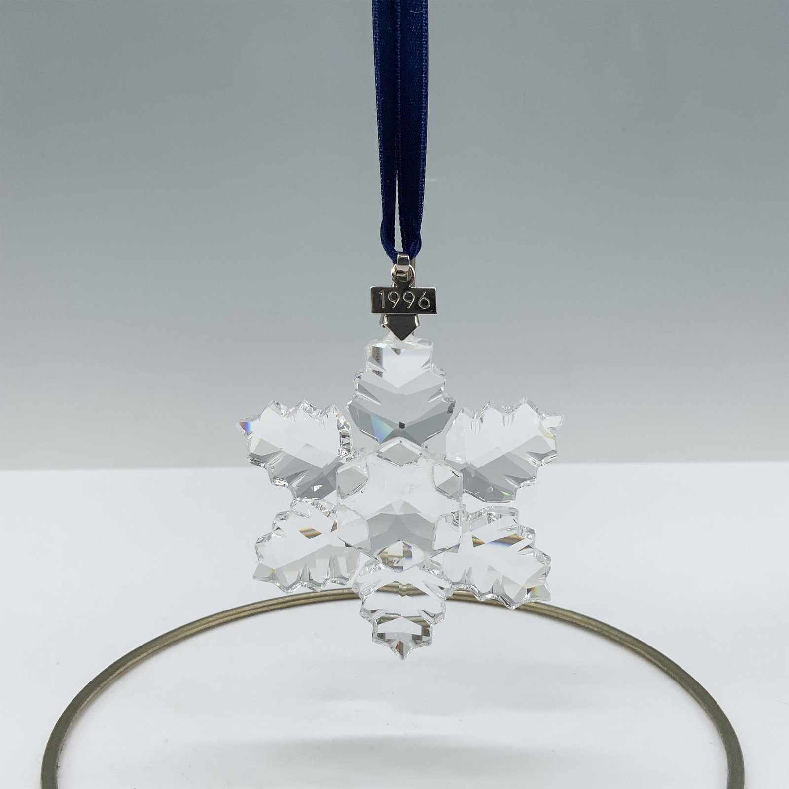Swarovski Crystal Ornament, 1996 Christmas Ornament: Limited edition crystal ornament that has 6 leaf shaped points and a metal tag with 1996 etched on it. Swarovski backstamp. 199734. This item has its original box 6.5"L x 5.5"W x 1"H. Artist: Martin Z
