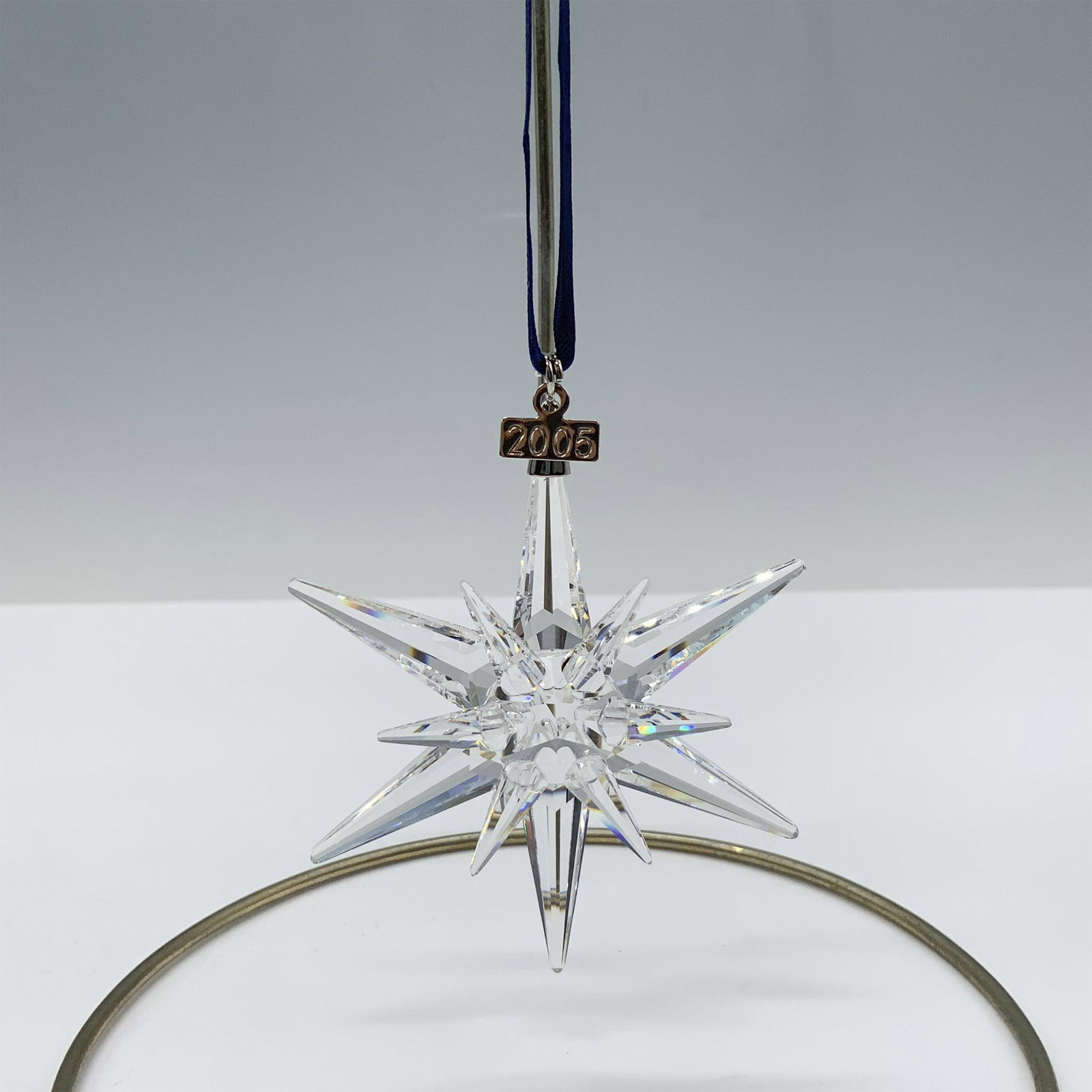 Swarovski Crystal Ornament, 2005 Christmas Ornament: Limited edition crystal ornament with a metal tag reading 2005 that features 6 short points and 6 long points to complete a beautiful snowflake design. Swarovski backstamp. 680502. This item has its o