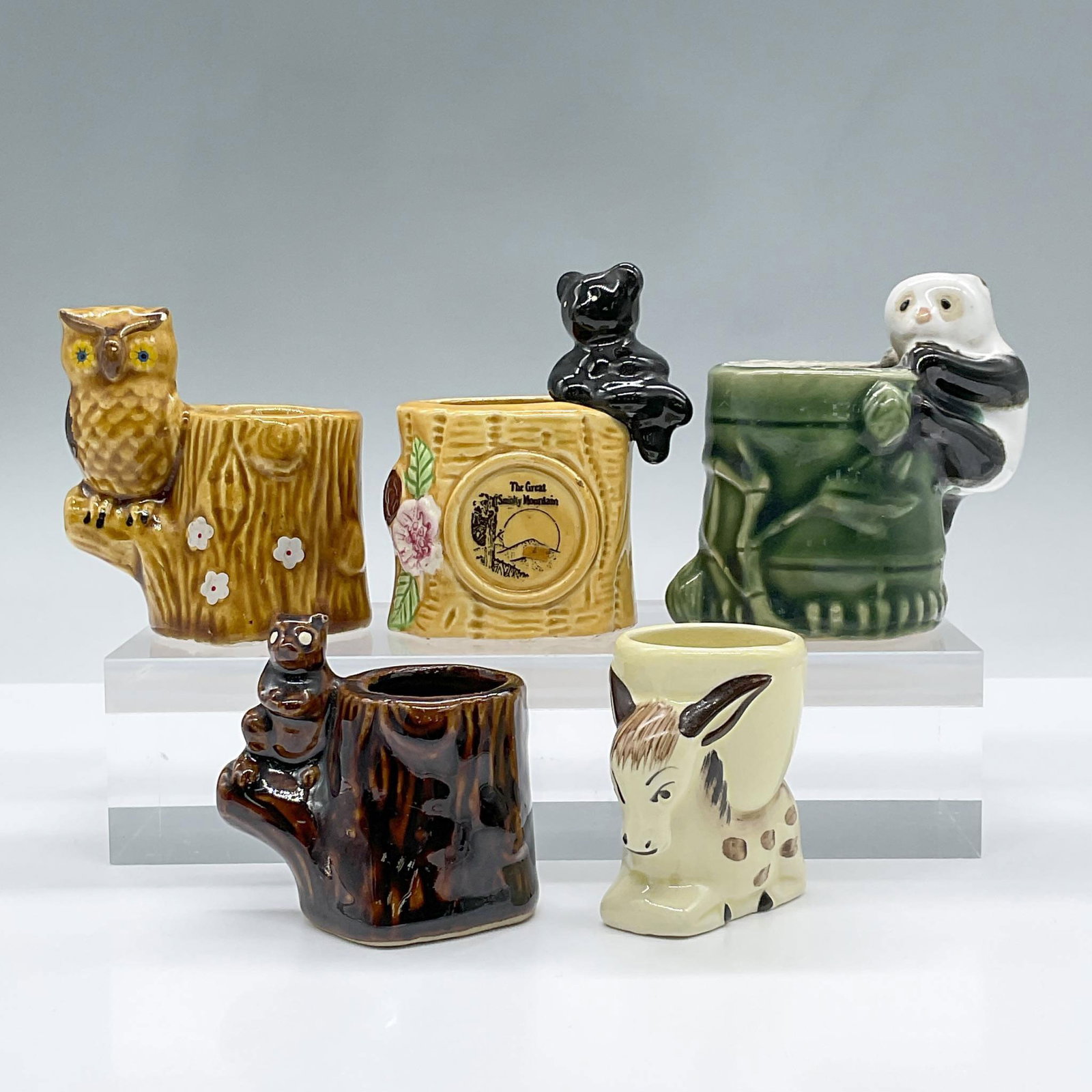 5pc Animal Toothpick Holder: An adorable array of ceramic animal tooth pick holders including a seated donkey, an owl on a tree, two bears on trees and a panda on bamboo. Largest measures 3.75"L x 2.5"W x 3.5"H. Issued: 20th cent