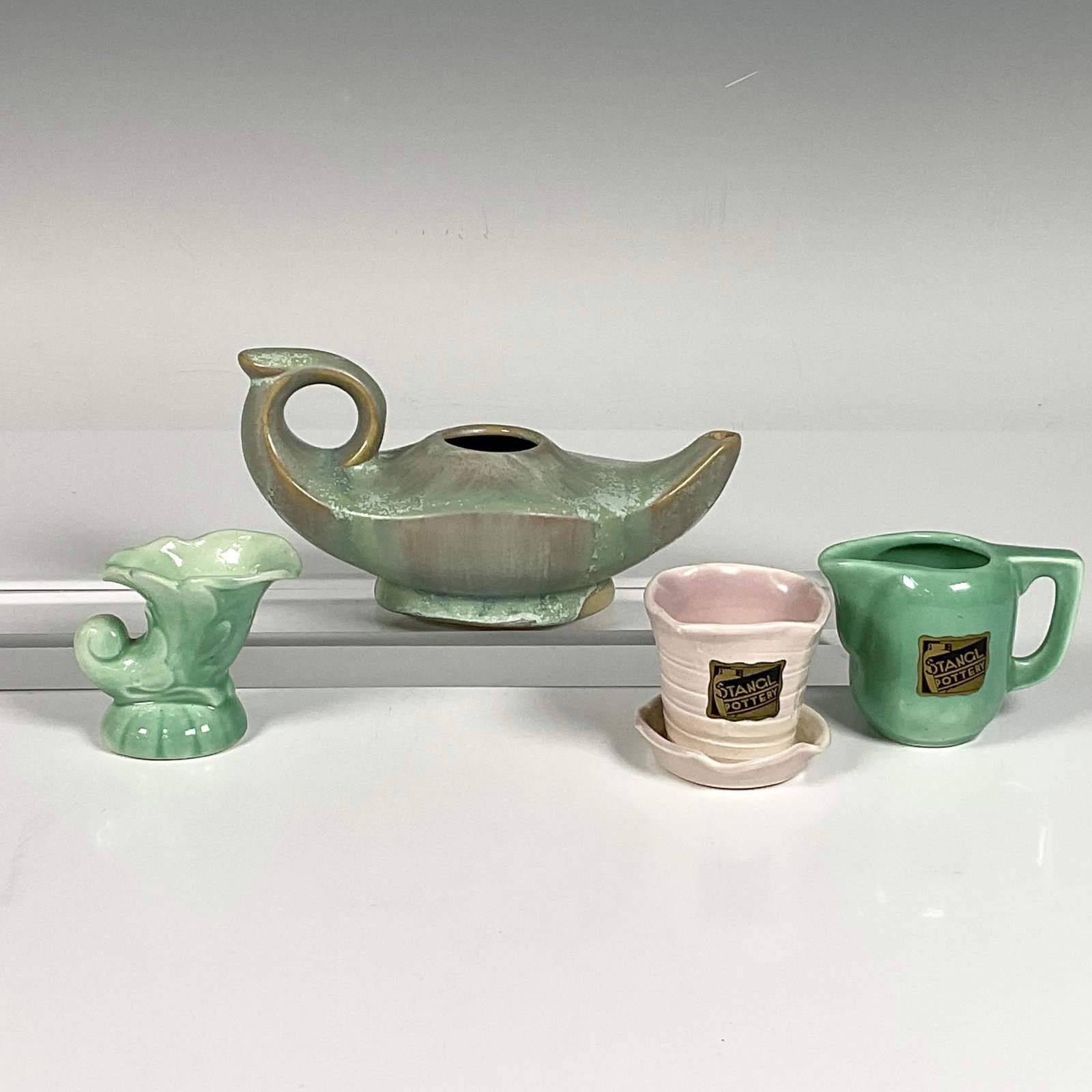 4pc Stangl Miniature Pottery Collection: This adorable collection includes a miniature green glossy pitcher, a pink glossy planter, a green glossy horn, and a matte greenish Aladdin lamp. The pitcher, planter and lamp are stamped Stangl. The