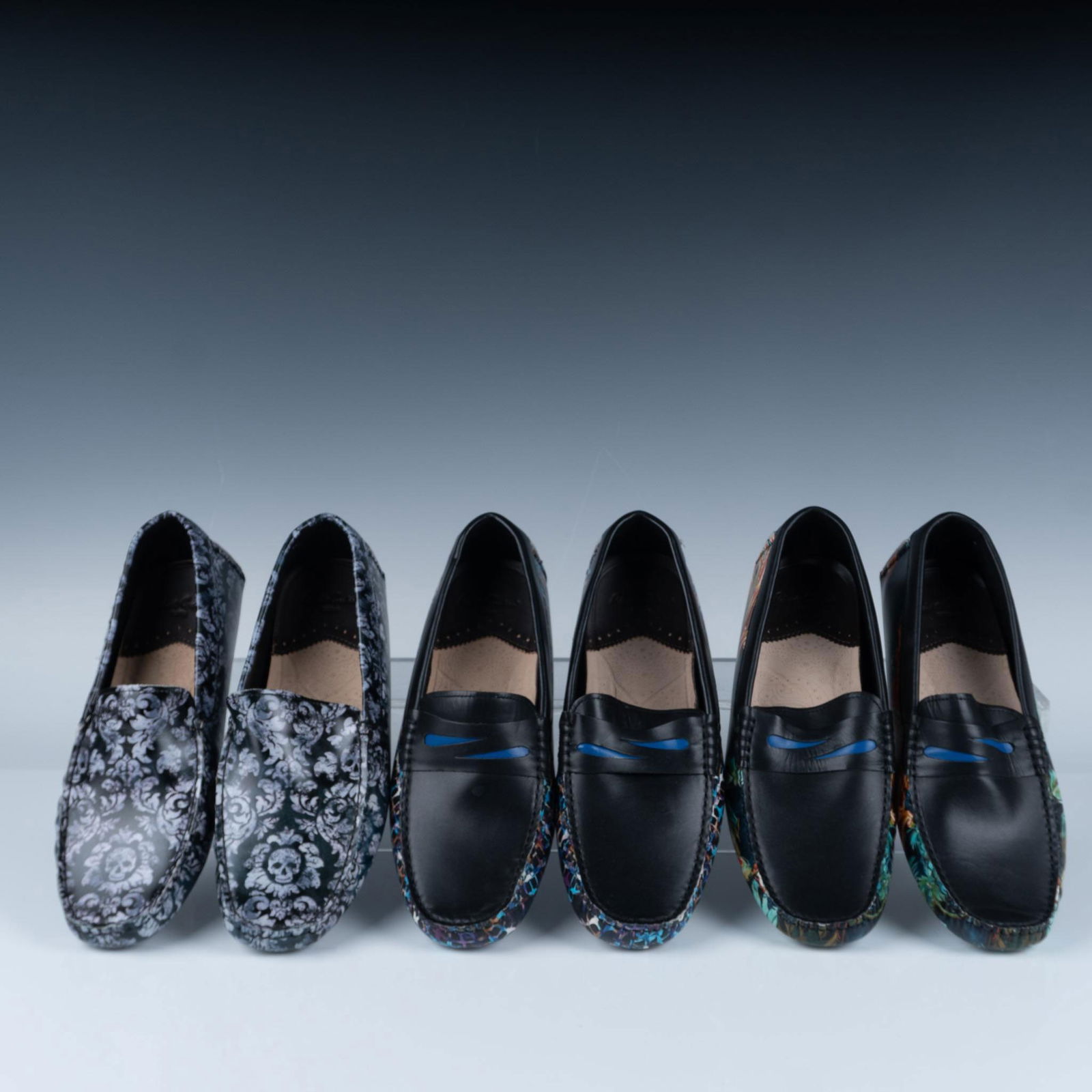 3 Pairs of Robert Graham Men's Loafers: Size: 9. This collection of loafers features a bold mix of classic and statement designs. The lot includes black leather loafers with unique accents, such as colorful geometric patterns, tropical prin