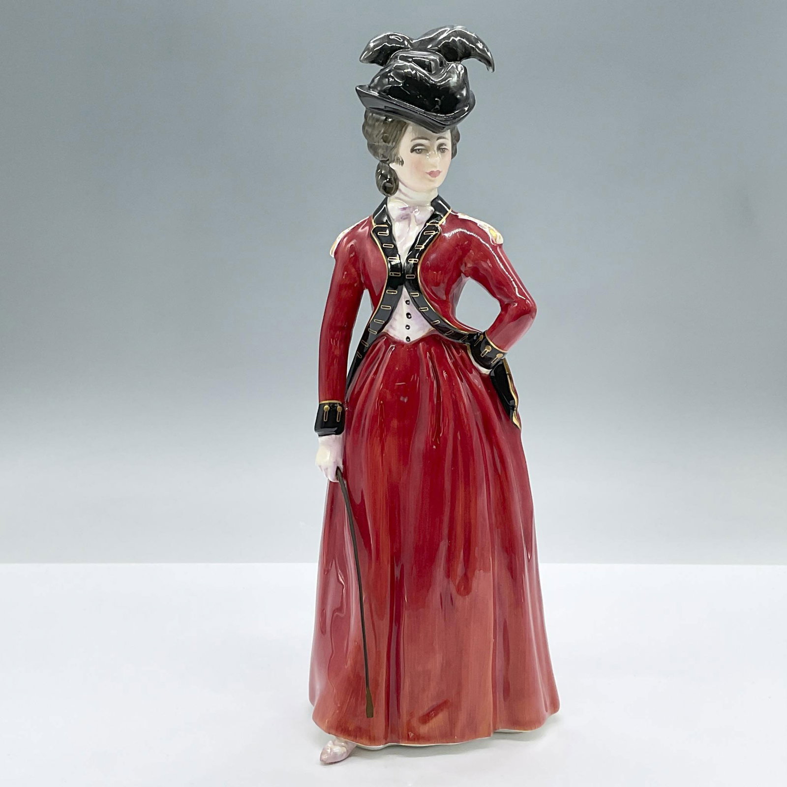 Lady Worsley HN3318 - Royal Doulton Figurine: From the Reynolds Ladies series, this limited edition figure wears a red riding habit with black trimmings and gilded gold accents. Royal Doulton backstamp. Artist: Peter Gee Issued: 1991 Dimensions: 