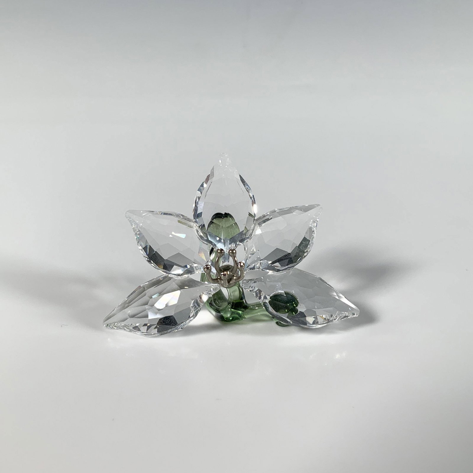 Swarovski SCS Crystal Figurine, Orchid: A gorgeous multi-faceted figure of a delicate orchid, beautifully embellished with metal and smooth green accents. SCS 2013 membership joining and renewal gift. Swarovski mark. This item has its origi