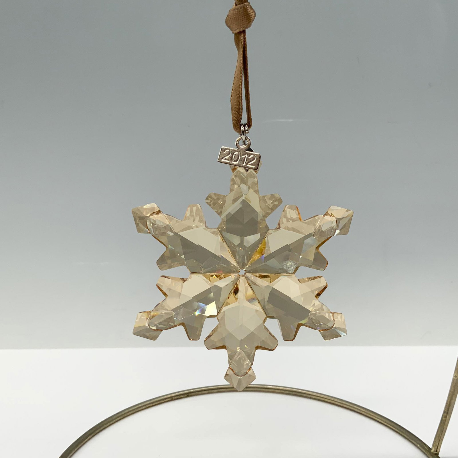 Swarovski Crystal 2012 Christmas Ornament: This retired 2012 Christmas Ornament in Golden Shadow was exclusively available for SCS members in 2012. This unique ornament lends a warm golden glow to your festive decorations. It sparkles elegantl