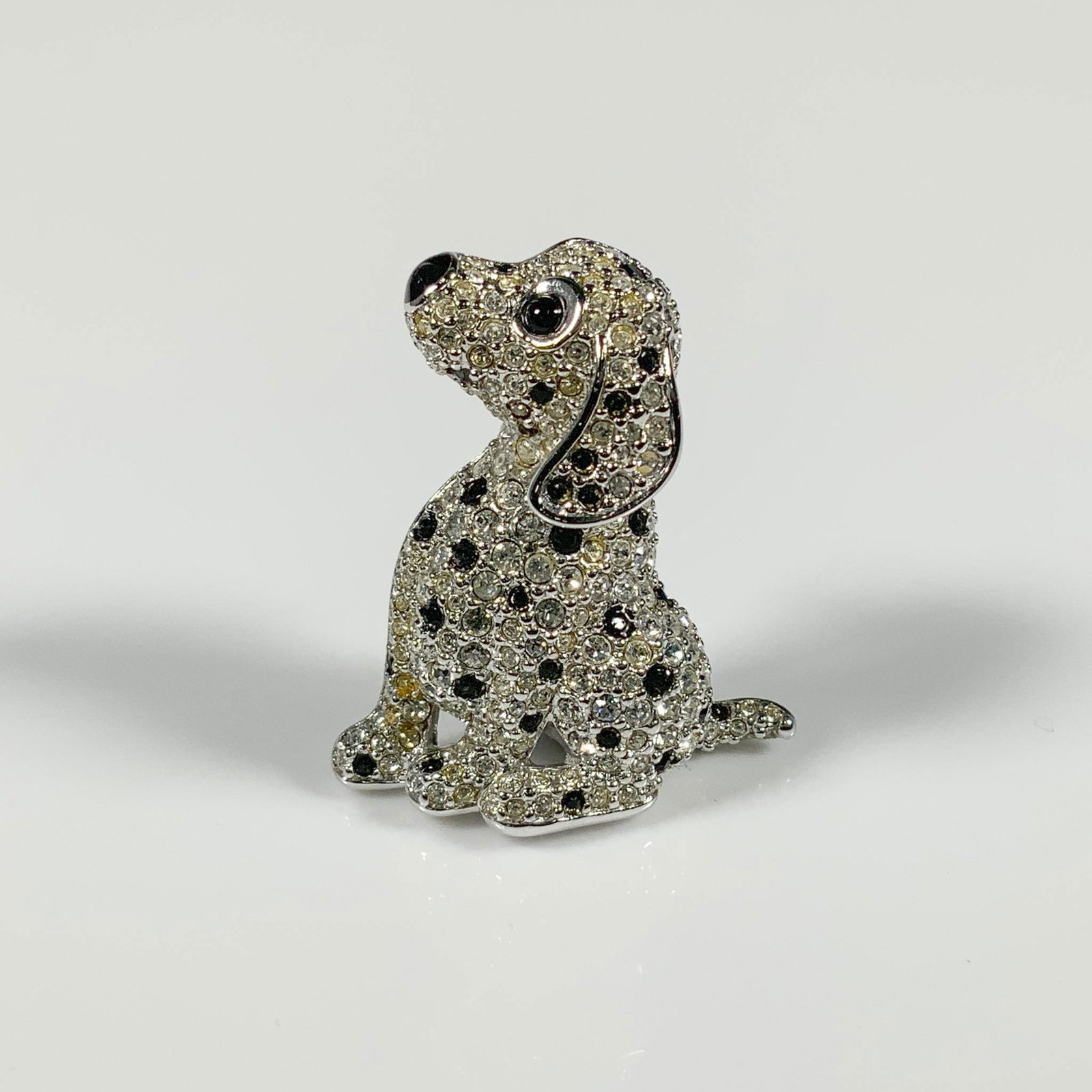 Swarovski Crystal Dalmatian Brooch Pin: This adorable brooch pin features a seated puppy, adorned with sparkling clear and black crystals, set in a radiant silver-tone finish. Swarovski hallmark. Dimensions: 1.25"L x 0.5"W x 1.5"H Manufactu
