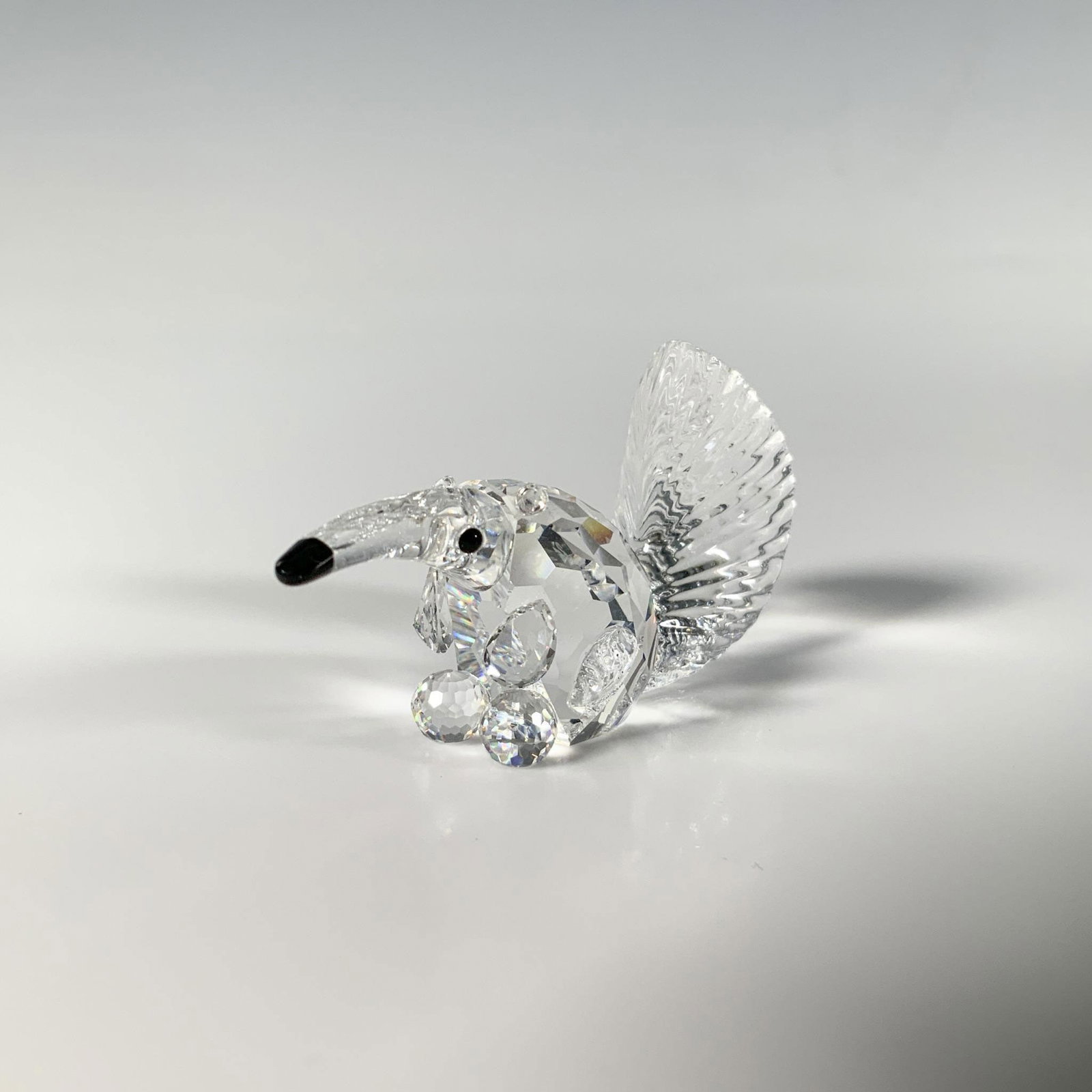 Swarovski Silver Crystal Figurine, Anteater: A sparkling small figure of an anteater, crafted from brilliant-cut crystal, accented with a black nose and eyes. Swarovski acid mark. This item has its original box: 3.25"W x 2.5"H. Artist: Adi Stock