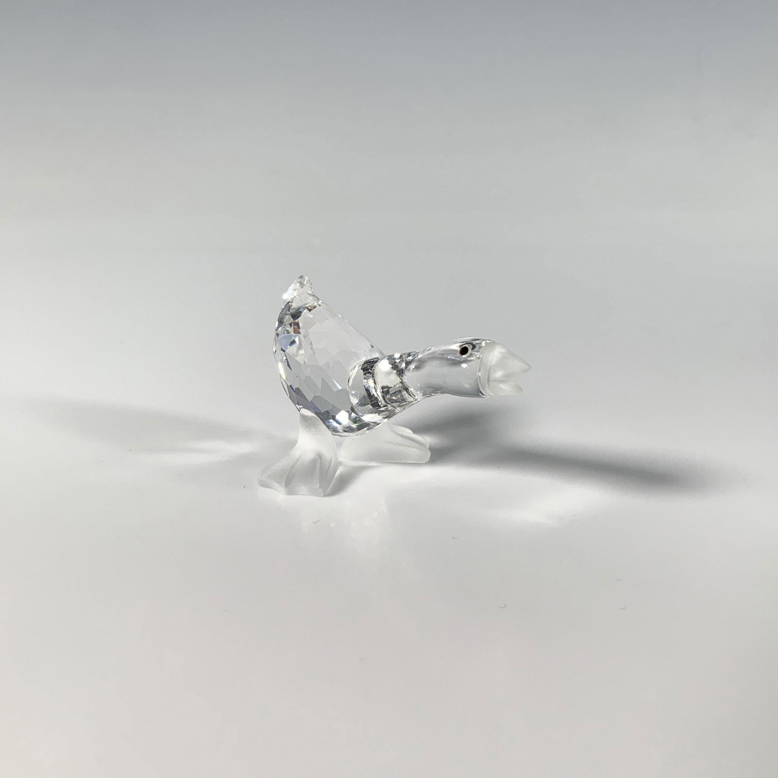 Swarovski Silver Crystal Figurine, Harry Gosling: A charming brilliant-cut and smooth crystal figure of a quacking goose, accented with frosted feet and beak, with small black eyes. Swarovski acid mark. This item has its original box: 3.25"W x 2.5"H.