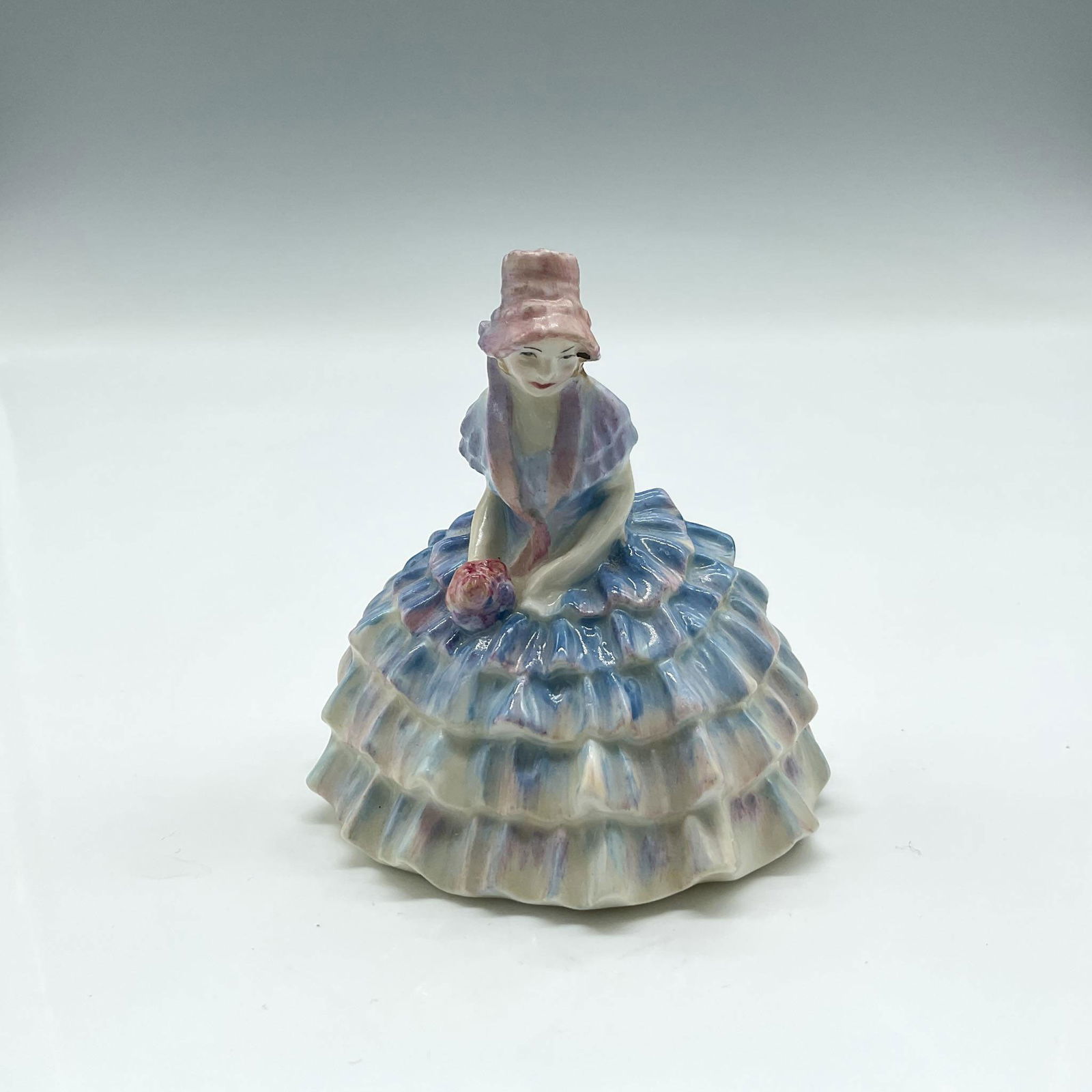 Chloe - M10 - Royal Doulton Figurine: Part of the miniature series, colored in lavender and blue ruffled dress. Royal Doulton backstamp. Artist: Leslie Harradine Issued: 1932 - 1945 Dimensions: 2.75"H Manufacturer: Royal Doulton Country o
