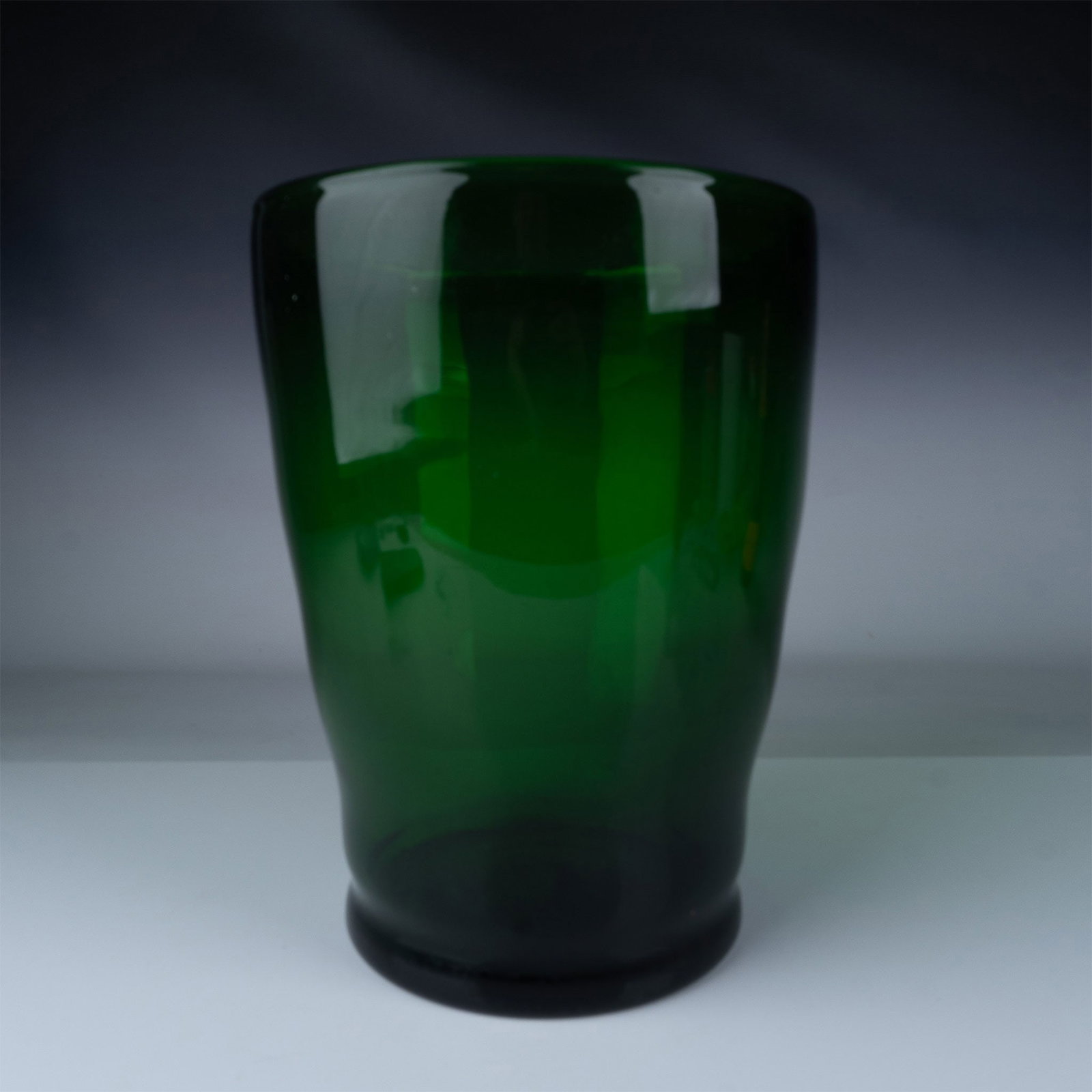 Contemporary Art Glass Green Vase: This striking green glass vase is a bold and modern piece of art glass, showcasing a sleek, minimalist design. Its deep green hue is complemented by smooth, flowing curves, creating a captivating visu