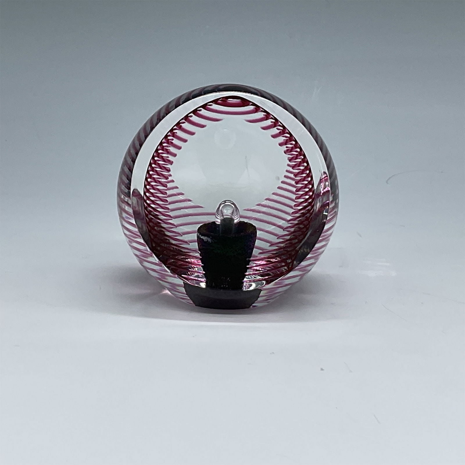 PinkSpiral Design Paperweight, Signed: A unique glass paperweight signed on the bottom with the artist's signature and "1991 WEZ9102.61/850," featuring a captivating pink spiral design and an encased decorative black element. This handmade