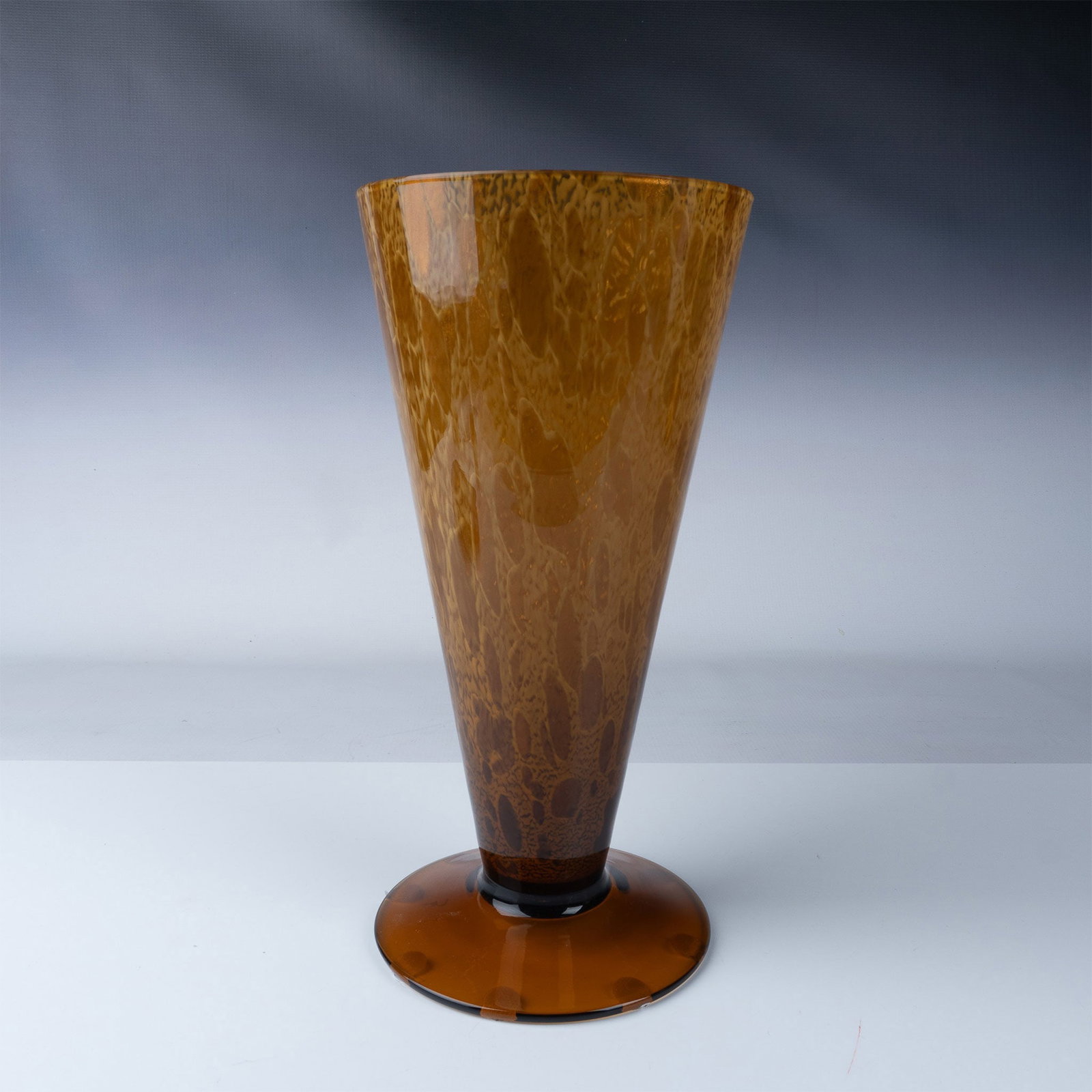Vintage Textured Cone Amber Glass Vase: This striking vintage amber glass vase features a smooth, glossy surface with an intricate design that creates a visually textured effect. The vase's elegant cone shape, paired with a flared rim and w