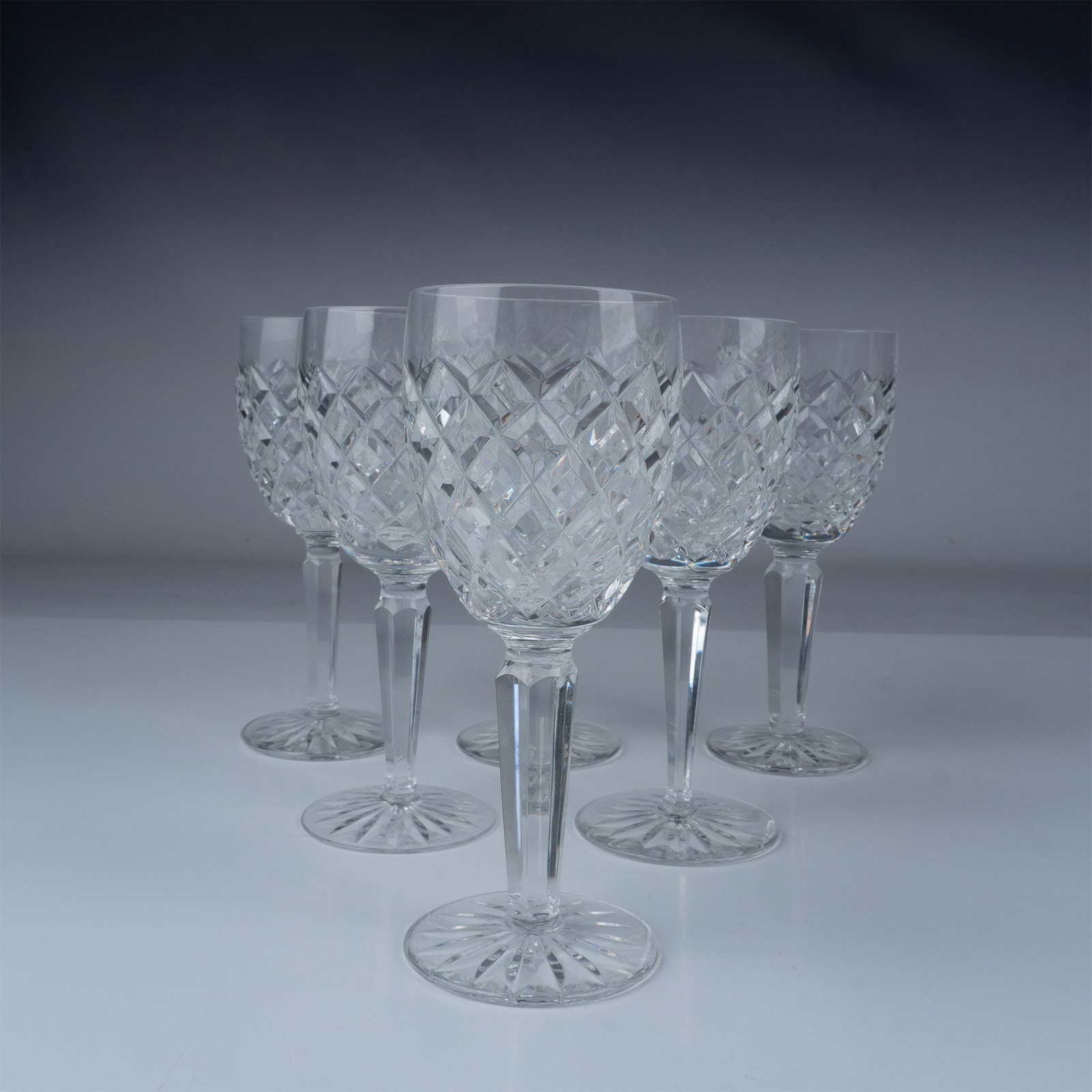 6pc Waterford Crystal Comeragh Claret Wine Glass Set: This set of six Waterford Crystal Claret Wine Glasses showcases the elegant Comeragh pattern, renowned for its intricate diamond quilted design and starburst base. The clear, cut glass crystal constru
