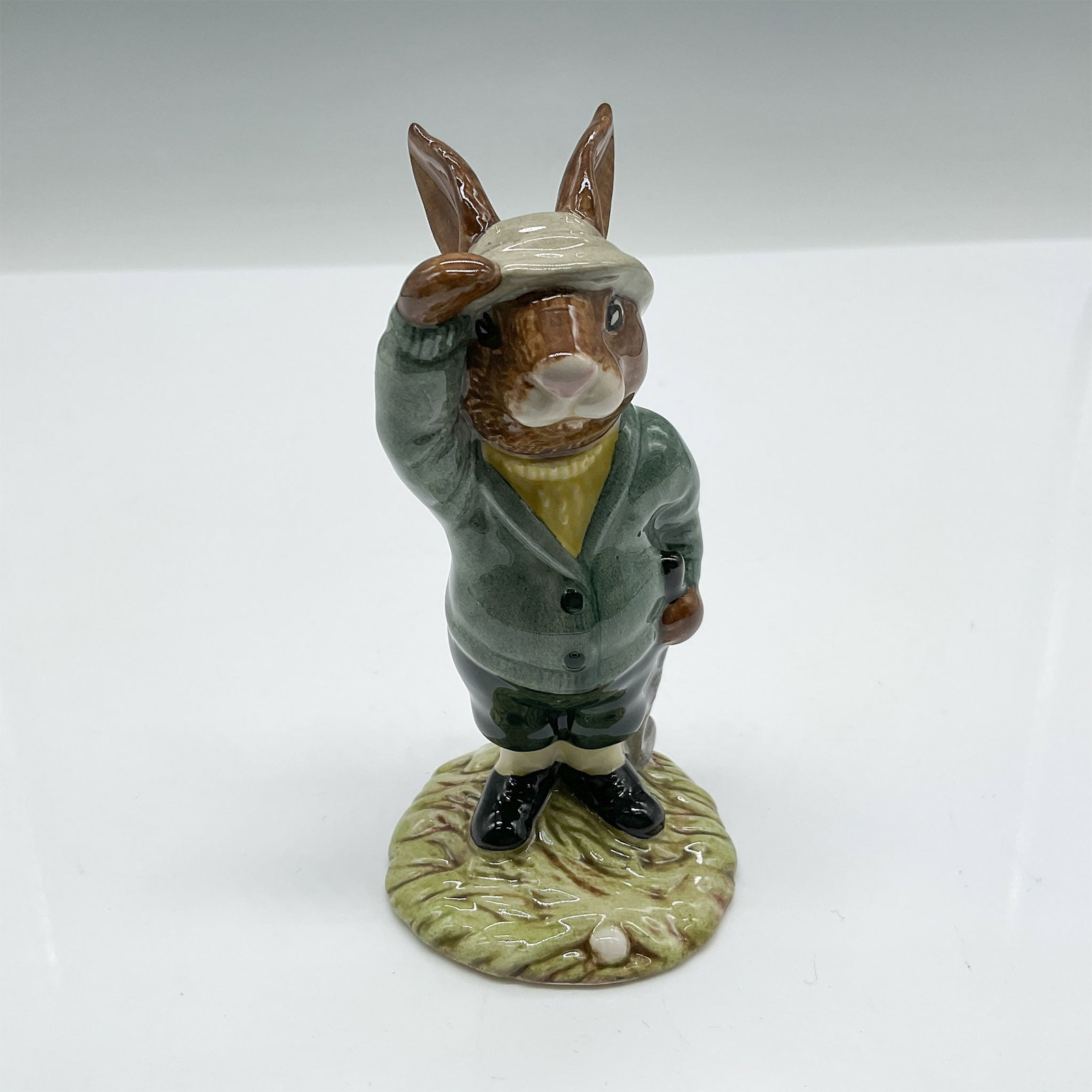 Royal Doulton Bunnykins Bogey Bunnykins Figurine DB32: This charming Royal Doulton Bunnykins figurine, titled Bogey Bunnykins, depicts an endearing rabbit golfer tipping his cap, dressed in green attire with intricate hand-painted details. Produced in 198