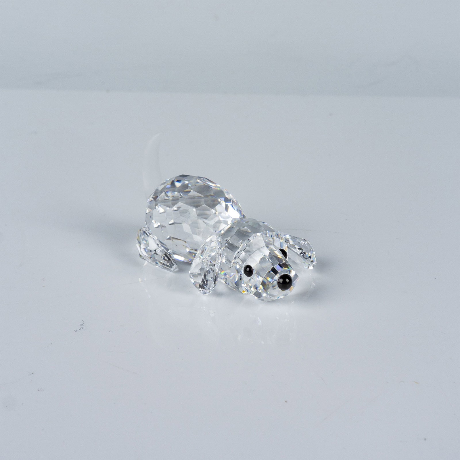 Swarovski Crystal Figurine, Playful Puppy with Original Box: Crafted with precision-cut crystal to showcase the brand's signature sparkle. The playful pose captures lifelike charm, with intricate detailing on the body and tail that reflect light brilliantly. Th