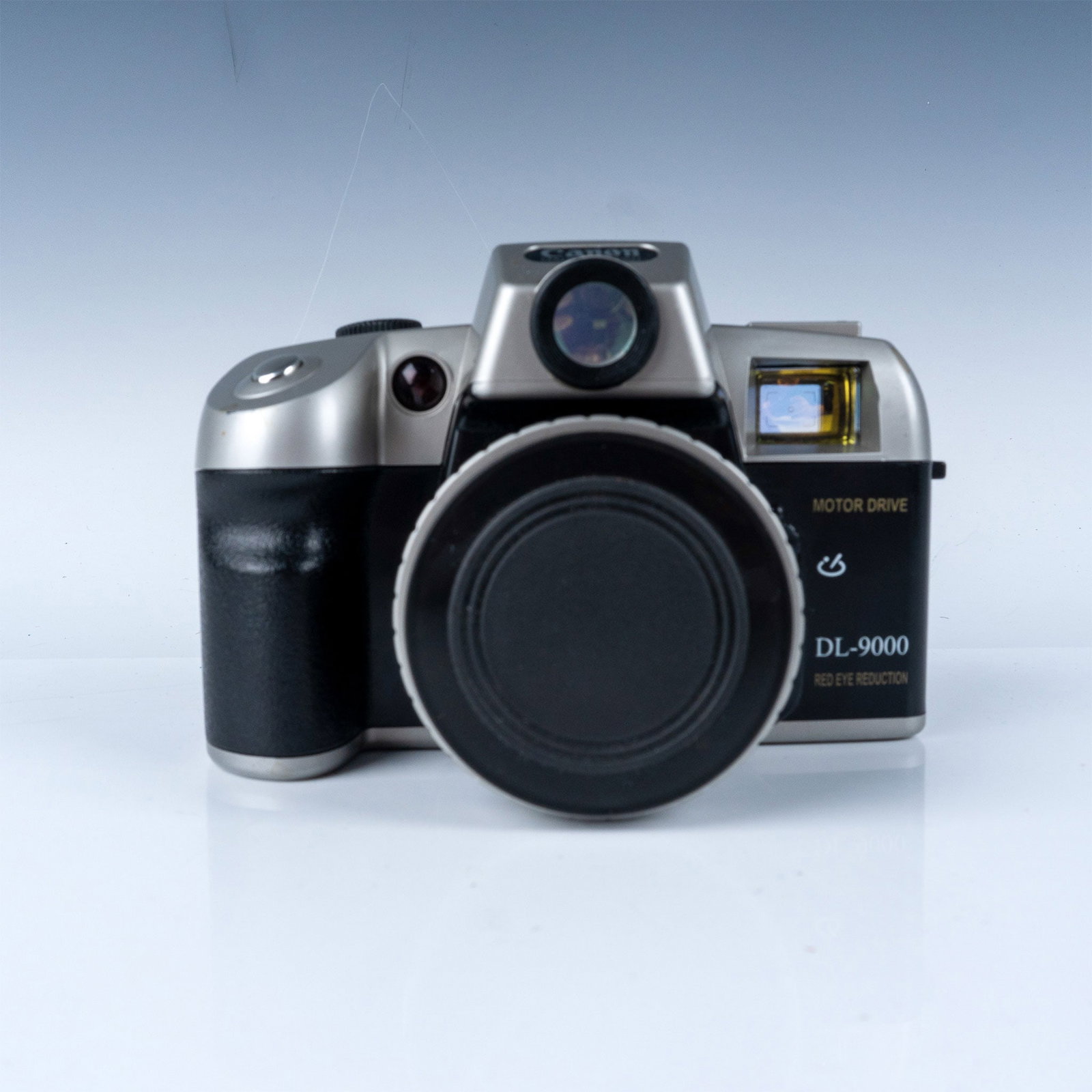 Canon DL-9000 Film Camera with 50mm Lens: This is a Canon DL-9000 film camera featuring a motor drive and an optical lens marked Focus Free. The camera includes red-eye reduction functionality and a 50mm f/6.3 lens. While the design mimics SL