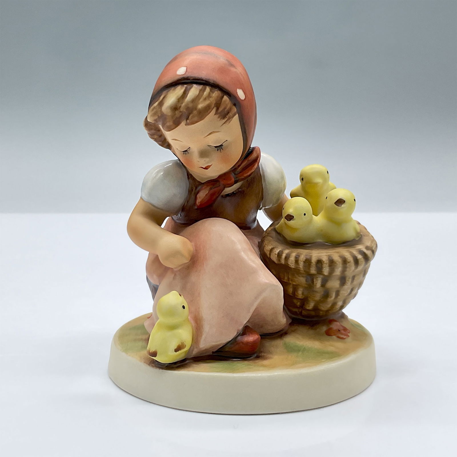 Goebel Hummel Figurine, Chick Girl: This endearing porcelain figure features a girl with a basket. Marked Goebel 57/I. Issued: 20th century Dimensions: 3.5"L x 3.5"W x 4.25"H Country of Origin: Germany