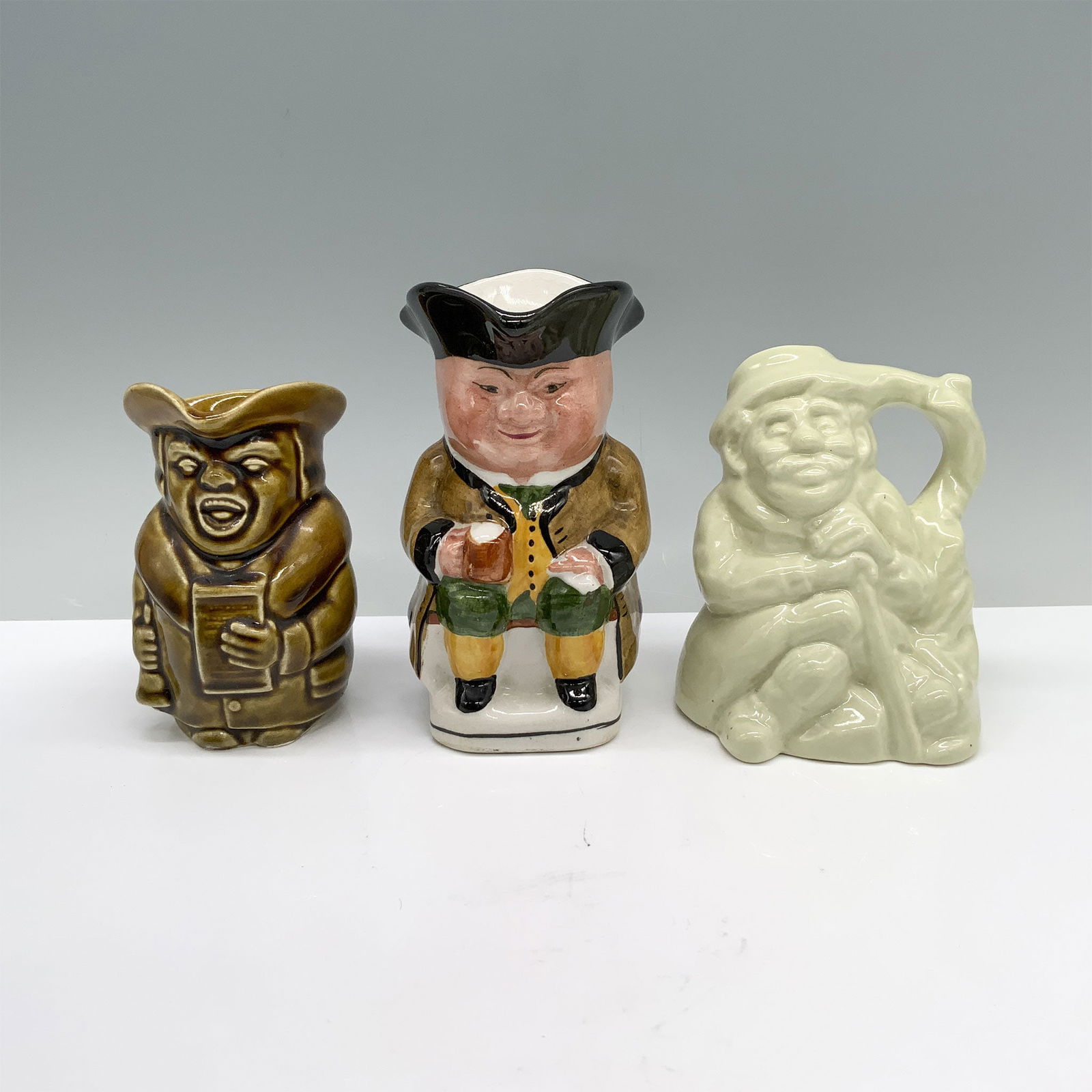 3pc Shorter & Son, Hornsea, and Wood & Sons Toby Jugs: 3 jugs that feature a stone-colored bell ringer, a light green miner taking a break to rest, and a colonial man dressed in tan, yellow, and green. Shorter and Son backstamp. Hornsea backstamp. Wood an