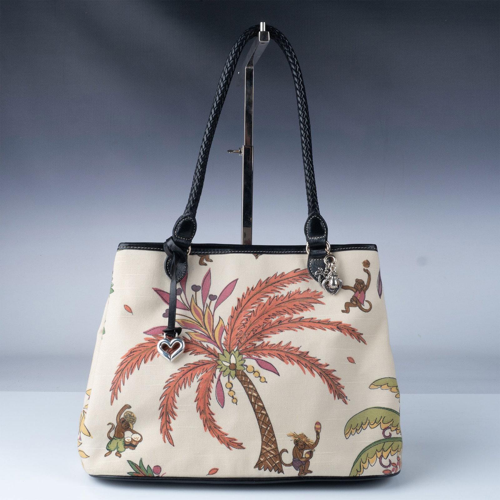 2pc Set of Brighton Monkey-Them Tote, and Leather Clutch: A stylish pair of Brighton bags showcasing the brand's signature design and craftsmanship. This set includes: a playful canvas tote adorned with a tropical monkey and palm tree motif, accented by Brig