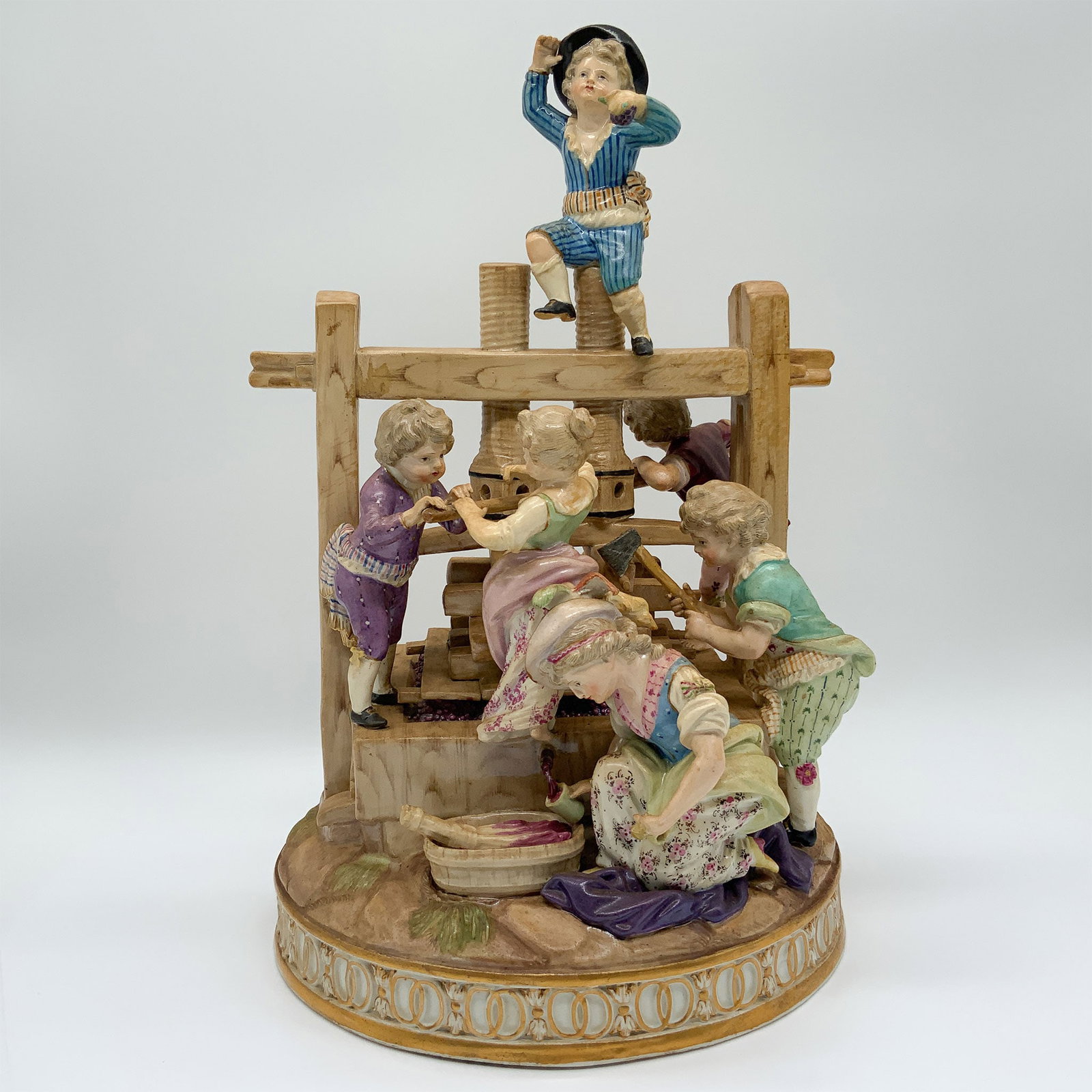 Meissen Porcelain Figurine of Children Harvesting Grapes: This lot features a charming Meissen porcelain figurine group depicting children in a rural setting, crafted by the renowned German porcelain manufacturer, known for their intricate designs and except