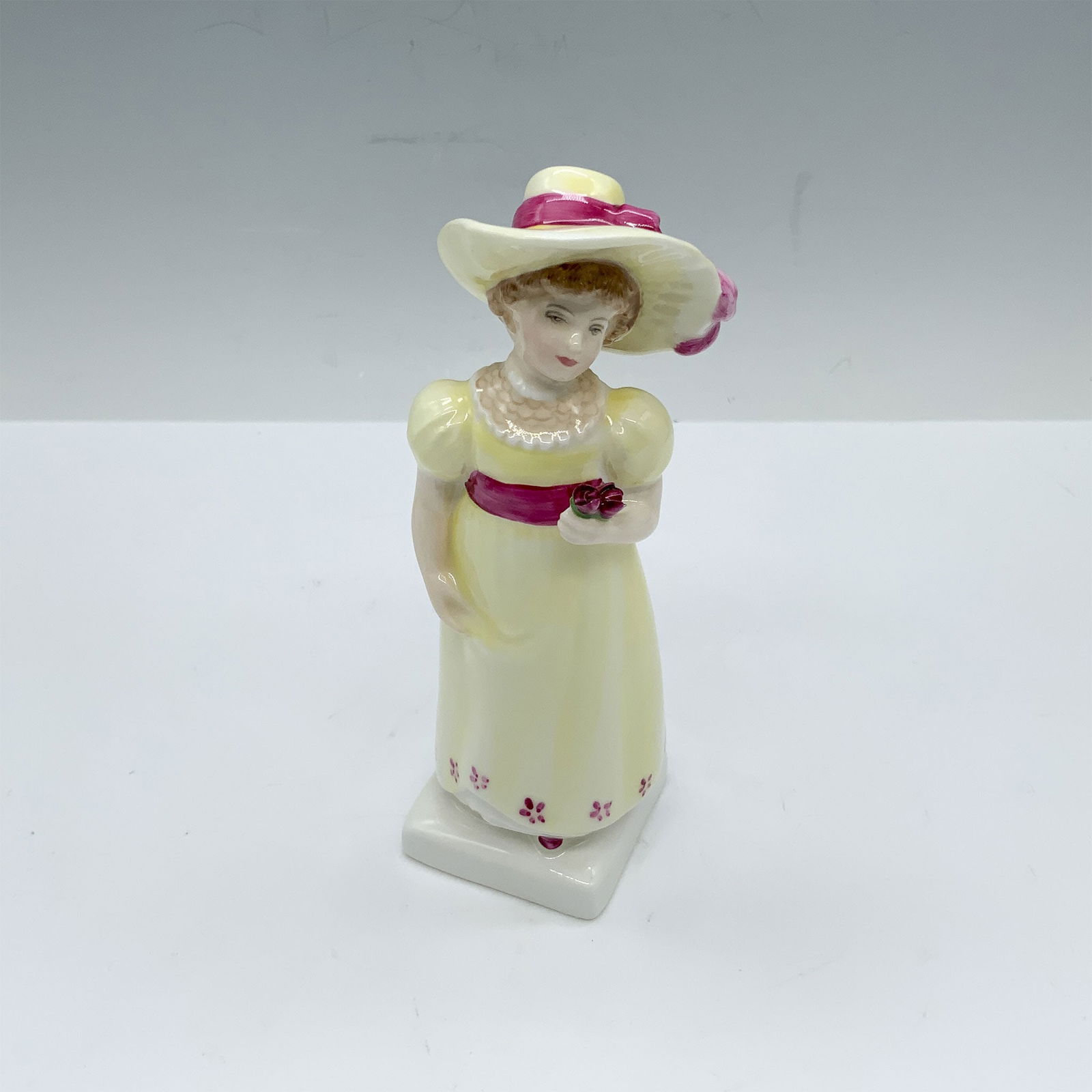 Royal Doulton Bone China Figurine, Lori HN2801: This girl in a yellow dress holding roses figure from the Kate Greenaway Collection is based of one of Kate's books named Under The Window which contains idyllic verses concerning children who endless