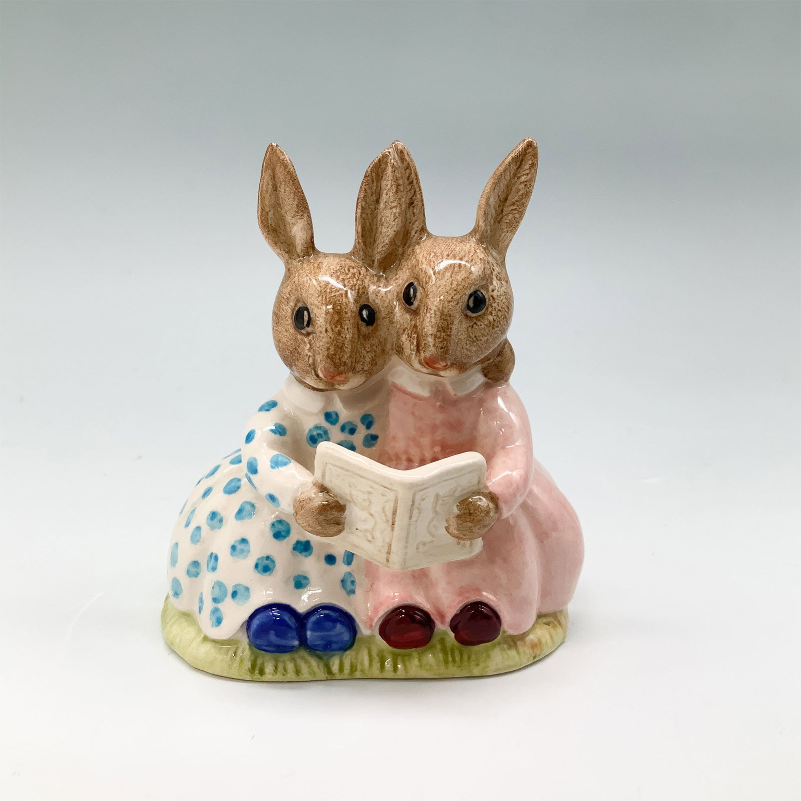 Royal Doulton Bunnykins Figurine, Storytime DB9: Fine bone china Royal Doulton Bunnykins figurine titled Storytime, DB9. Features two rabbits seated and reading a book. Marked with a Royal Doulton backstamp on the underside, indicating authenticity.