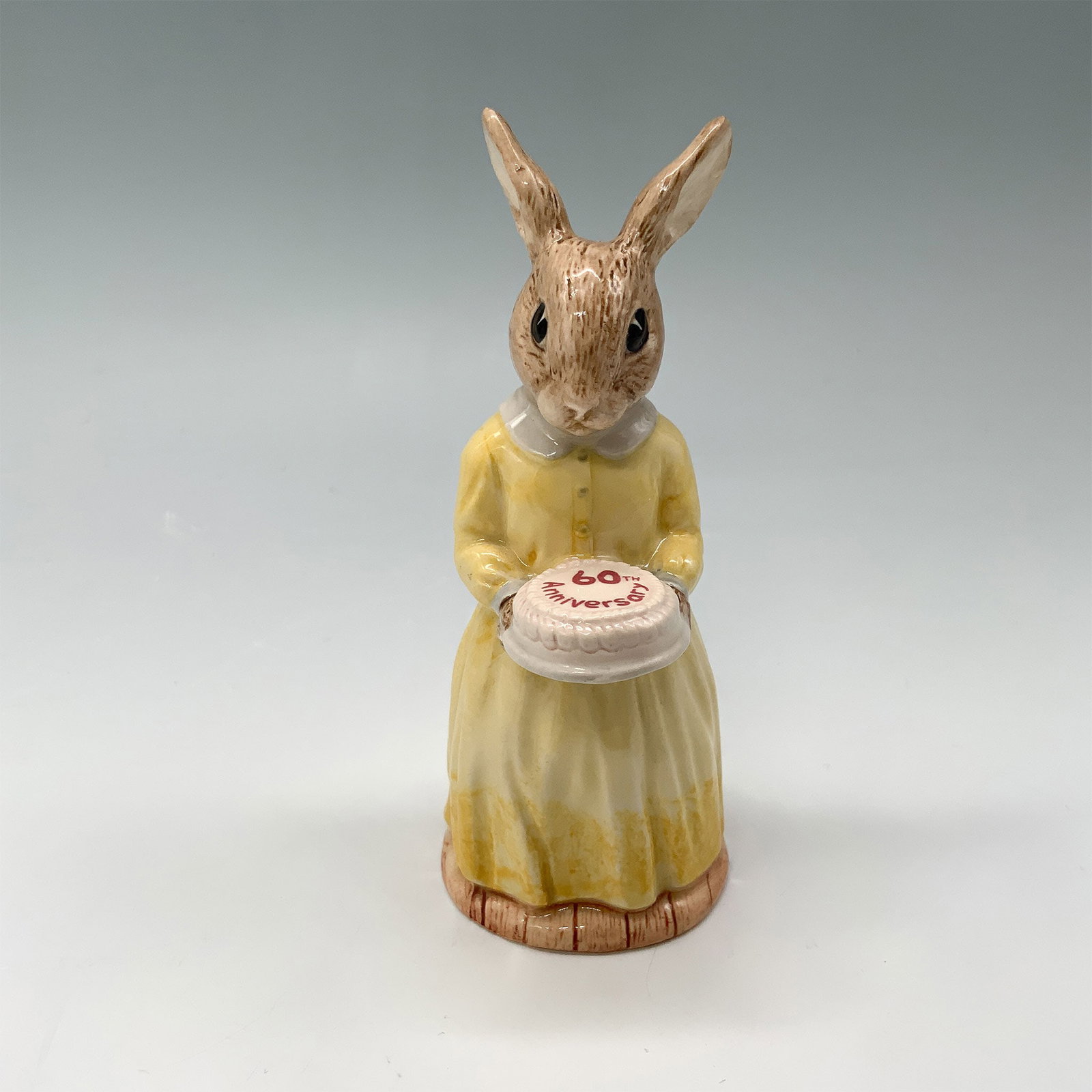 Royal Doulton Bunnykins Figurine, 60th Anniversary DB137: Celebrate six decades of Bunnykins charm with this exquisite Royal Doulton 60th Anniversary figurine, model DB137. Crafted in 1994, this delightful piece features a bunny adorned in a lemon-yellow dre