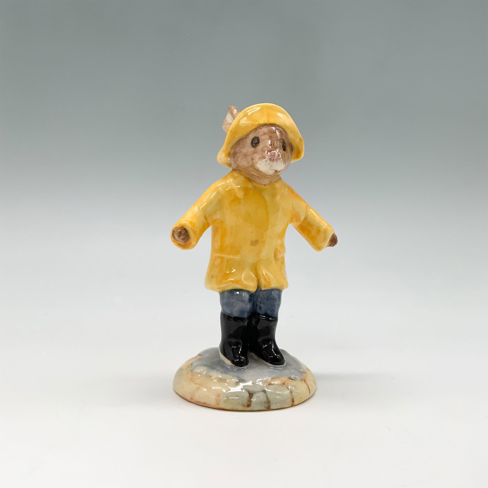 Royal Doulton Bunnykins Figurine, Rainy Day DB147 with Box: Royal Doulton Bunnykins figurine titled Rainy Day model number DB147 issued between 1994 and 1997. The figurine features a bunny in a yellow raincoat and hat blue trousers and black boots splashing in