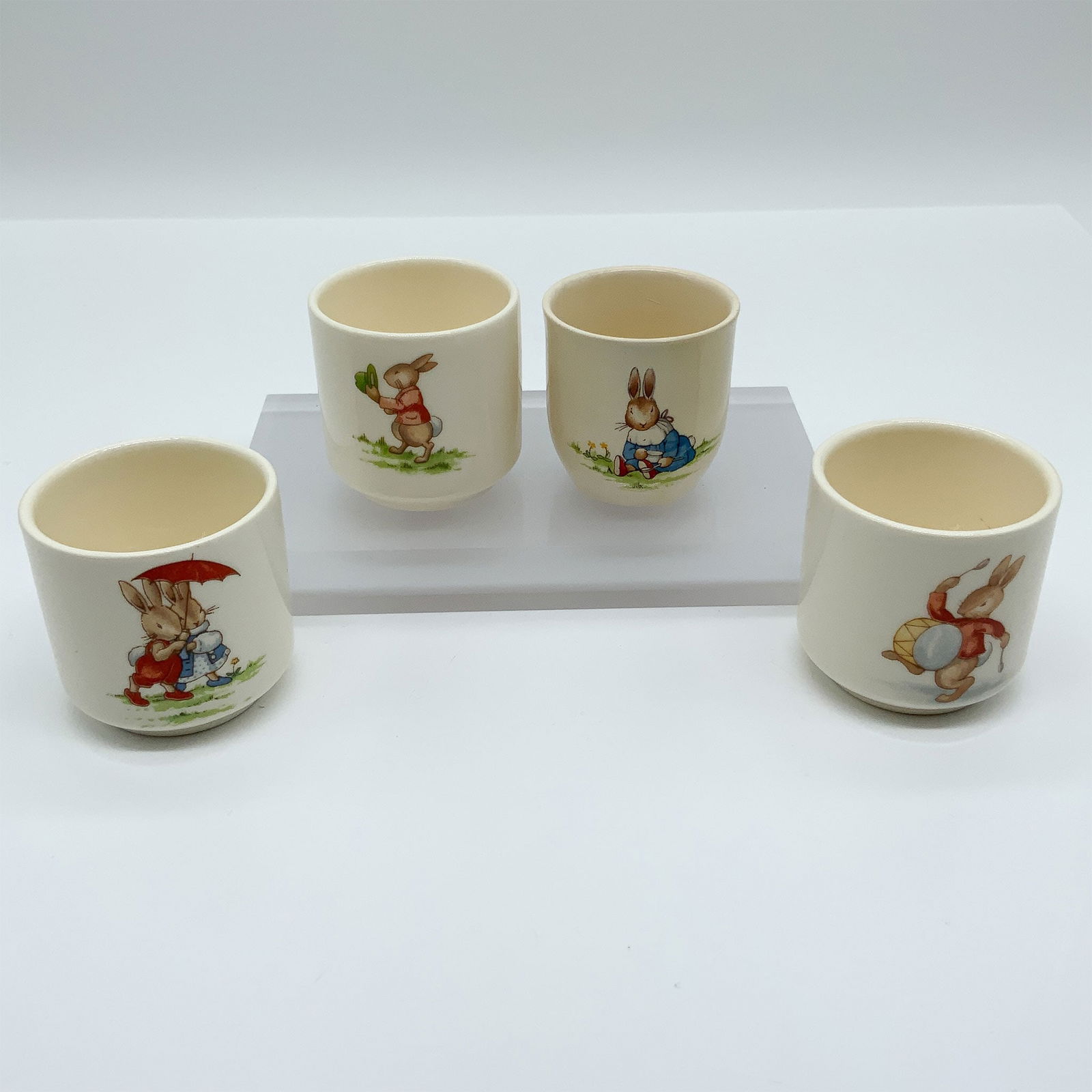 Royal Doulton Bunnykins, 4-Piece Egg Cup Set: This delightful set of four Royal Doulton Bunnykins egg cups features hand-painted scenes of the iconic Bunnykins characters, each in a different whimsical pose. The designs capture the playful charm