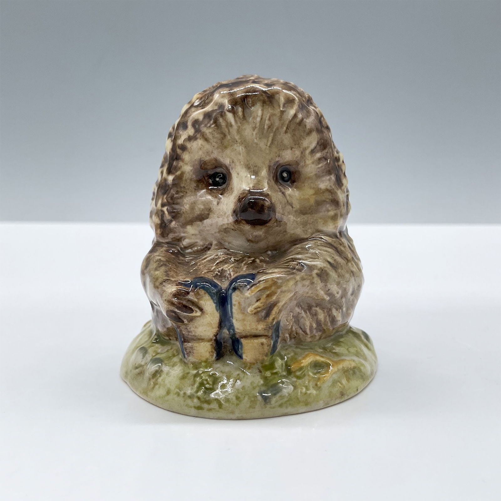 Beswick Beatrix Potter Figurine, Old Mr Pricklepin: Glossy porcelain. Adorable character modeled in brown fur and blue little shoes. Beswick Beatrix Potter backstamp. Issued: c. 1983 Dimensions: 2.5''L x 2.25''W x 2.5''H Country of Origin: England