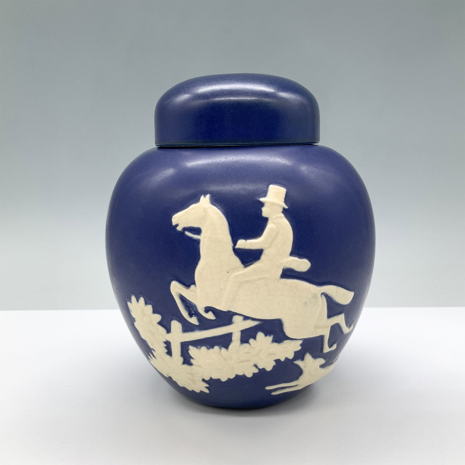 Weller Pottery Covered Blue Jar W/ Equestrian Scene: This exceptional Weller Pottery covered jar is a true collector's piece, capturing the elegance and craftsmanship of early 20th-century American art pottery. The jar features a stunning equestrian sce