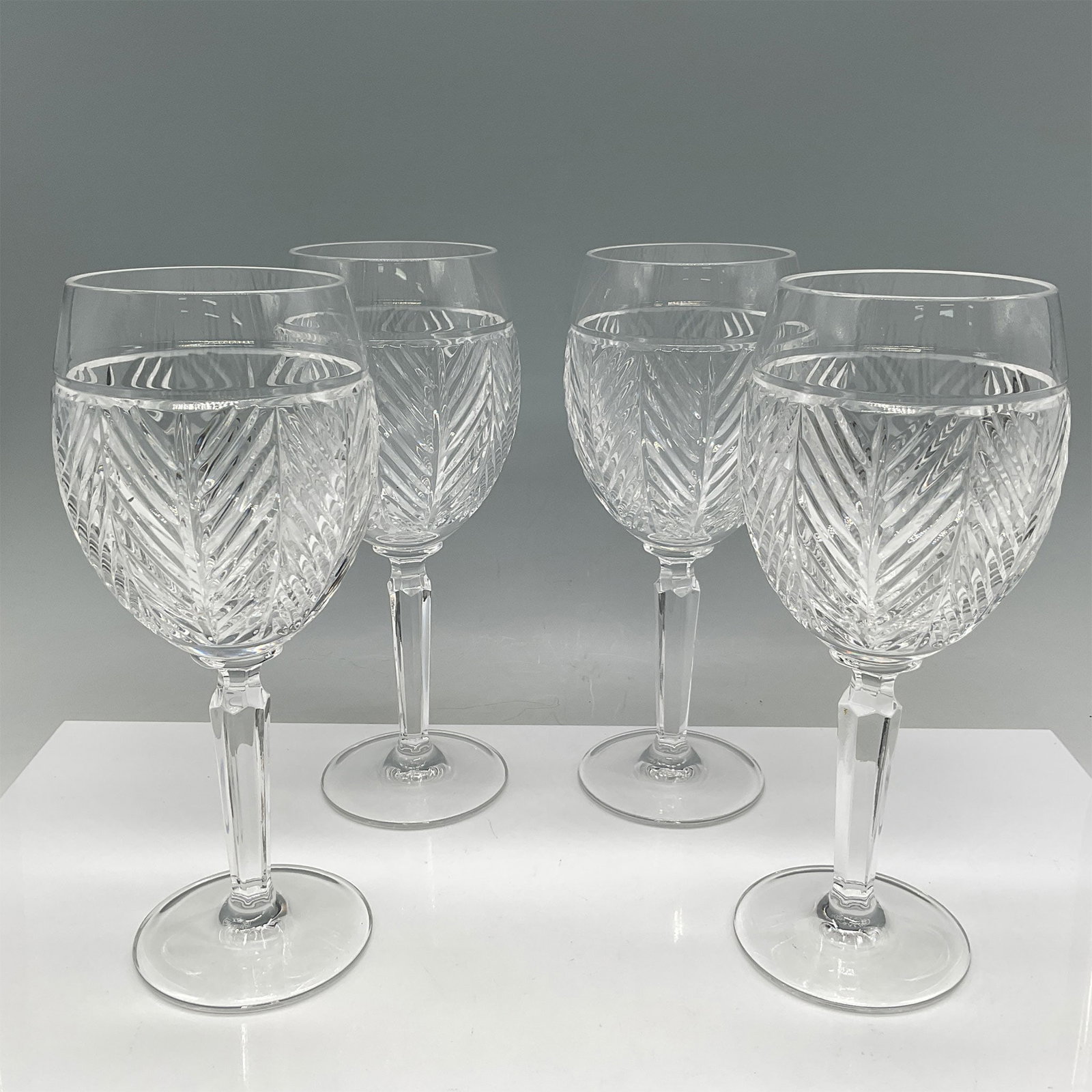 4pc Ralph Lauren Crystal Wine Glasses with Chevron Pattern: Ralph Lauren crystal wine glasses, featuring a sophisticated chevron-cut pattern. These glasses display a harmonious balance of elegance and craftsmanship, characteristic of Ralph Lauren's luxurious h
