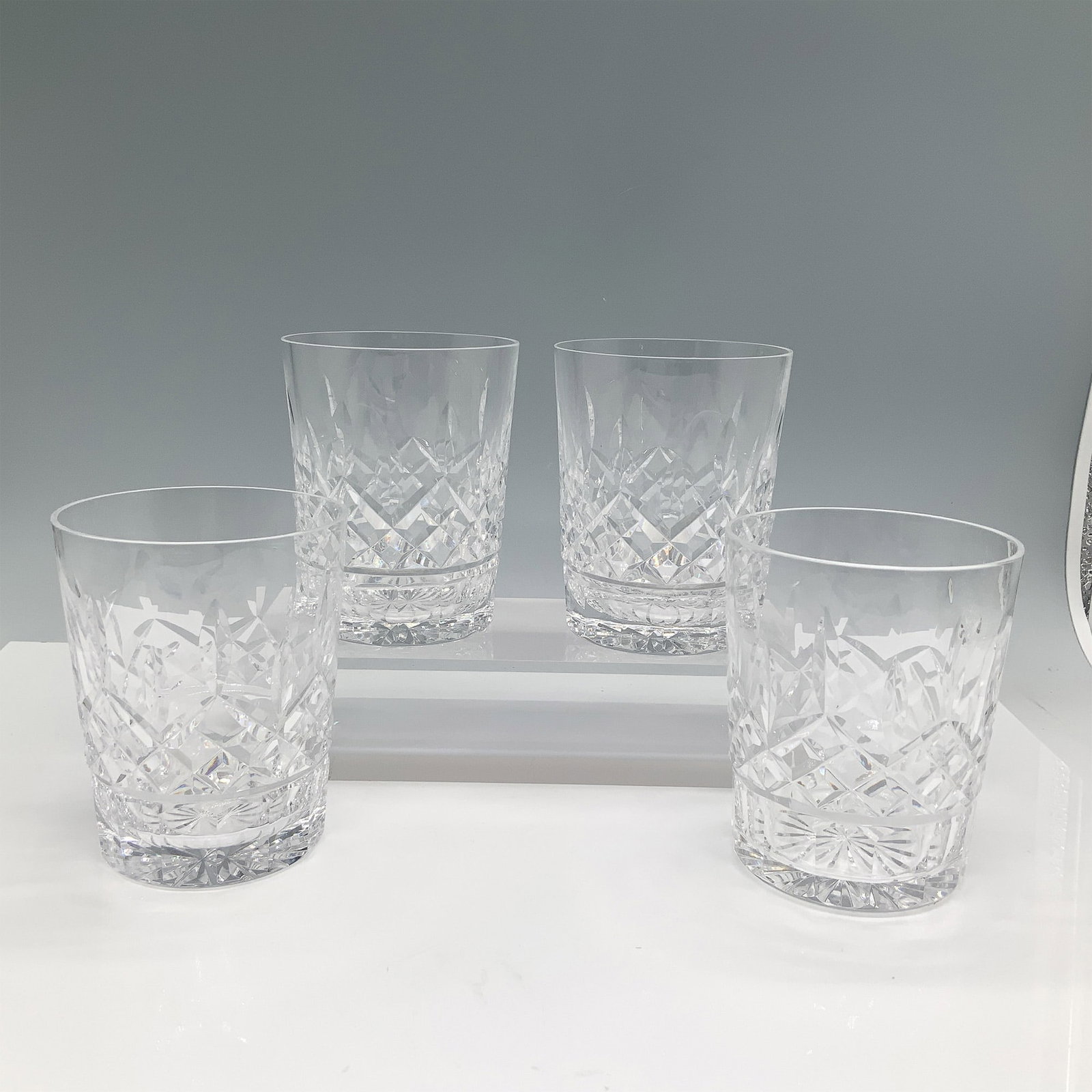 4pc Cut Glass Crystal Tumblers: Set of four crystal barware glasses featuring an intricate cut design. Each glass showcases a radiant pattern that reflects light beautifully, making them ideal for entertaining or display. Issued: 20