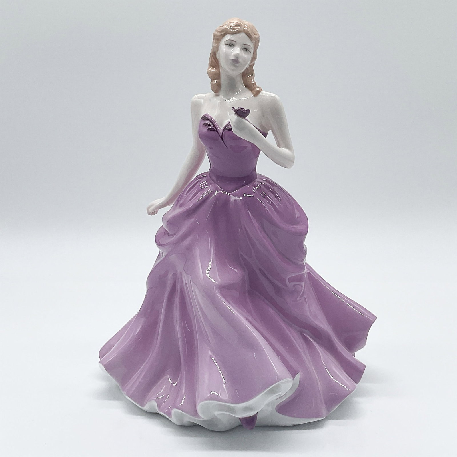 Victoria HN4623 - Royal Doulton Figurine: Royal Doulton porcelain figurine titled Victoria from the Figure of the Year collection, designed by John Bromley. Released as the Figure of the Year for 2005, this elegant piece features a young woma
