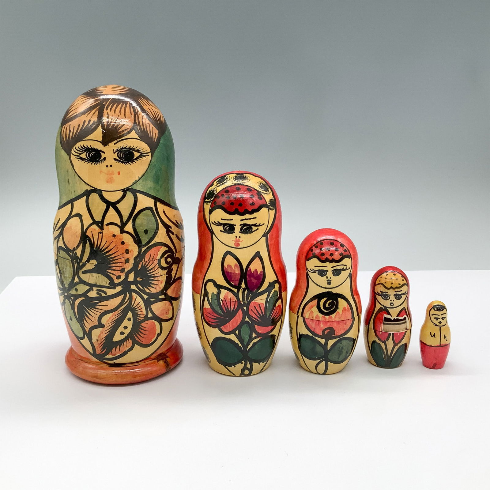 Russian Handcrafted Matryoshka Nesting Dolls: This exquisite 5-piece Russian Matryoshka doll set is hand-painted and marked "Vladivostok, Russia" on the base, dated September 15, 1994. Each nesting doll is adorned with vibrant floral and traditio