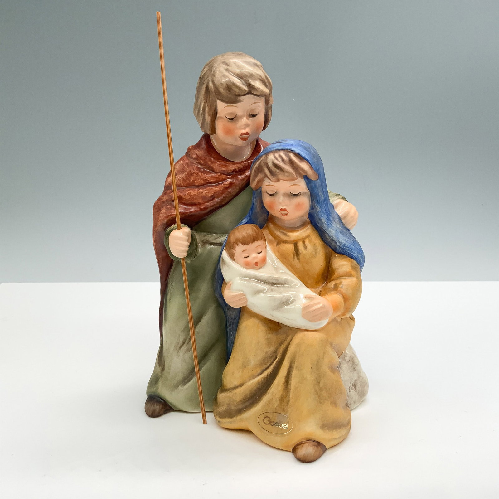 Goebel Porcelain Figurine, Merry Christmas: Hand painted porcelain figure depicting Mary, Joseph, and Baby Jesus. Goebel backstamp. Hand inscribed artist signature, date and title on the underside. Issued: 1995 Dimensions: 7"H Country of Origin