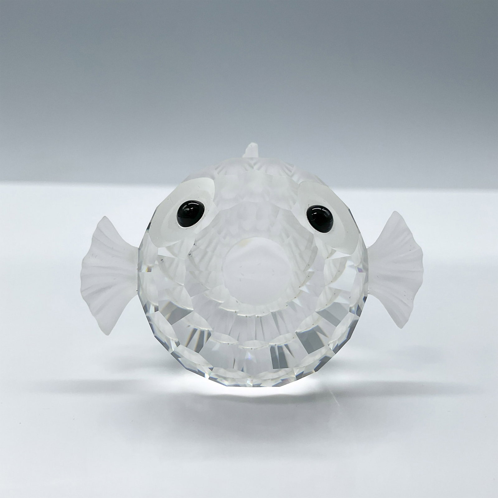 Swarovski Crystal Figurine, Blowfish - Large: Part of the South Sea collection. A pufferfish with a clear faceted crystal body and frosted crystal tail, mouth, and fins. Black crystal eyes. Swarovski etched backstamp. Includes a Swarovski velvet 
