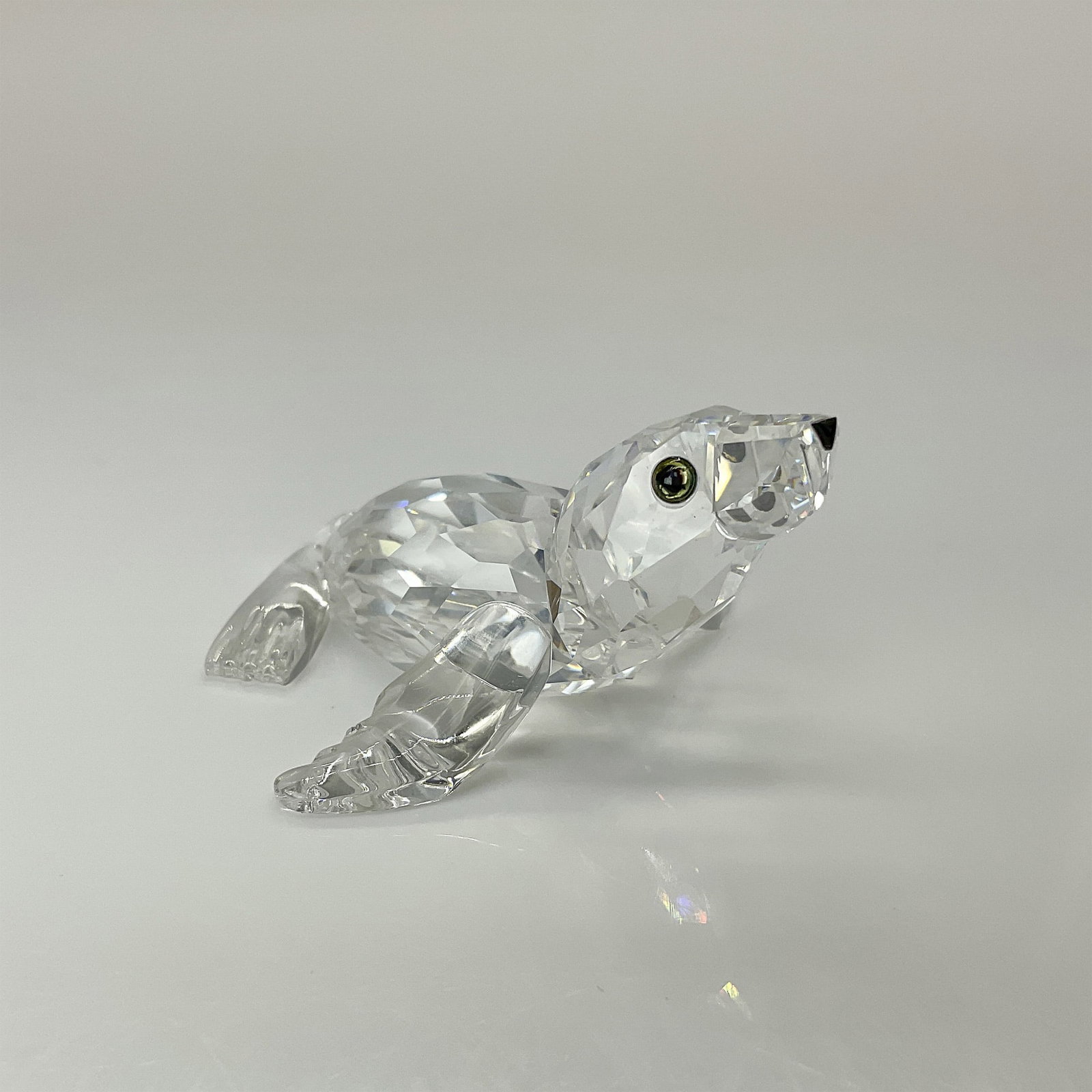 Swarovski Crystal Figurine, Sea Lion Baby 221120: Part of the Aquatic Worlds Collection, this adorable sea lion features a clear faceted crystal body, color-changing eyes, and a black nose, capturing its playful charm. Swarovski backstamp. This item 